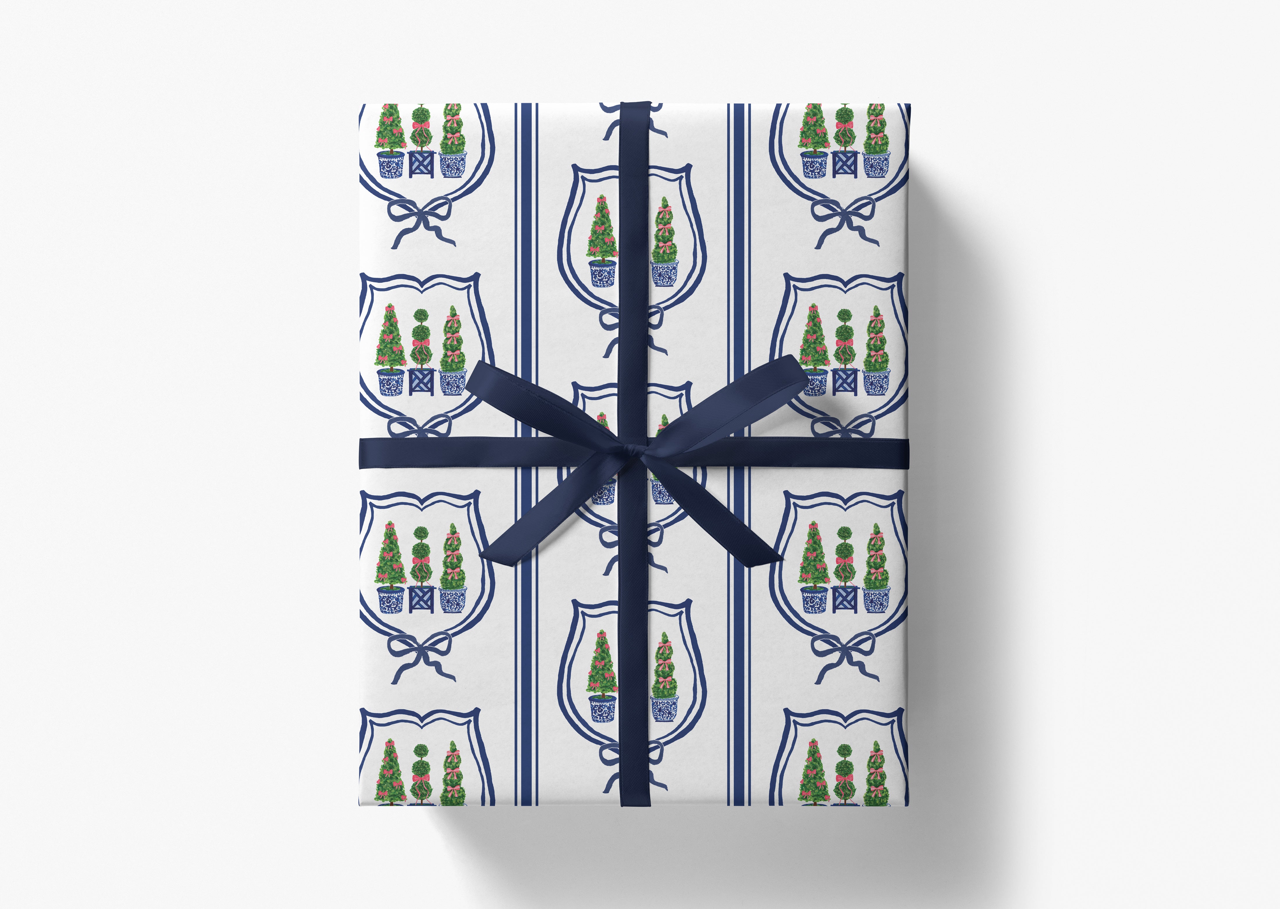 a gift box wrapped in a blue ribbon with a repeating pattern of shield-shaped designs and Christmas trees.
