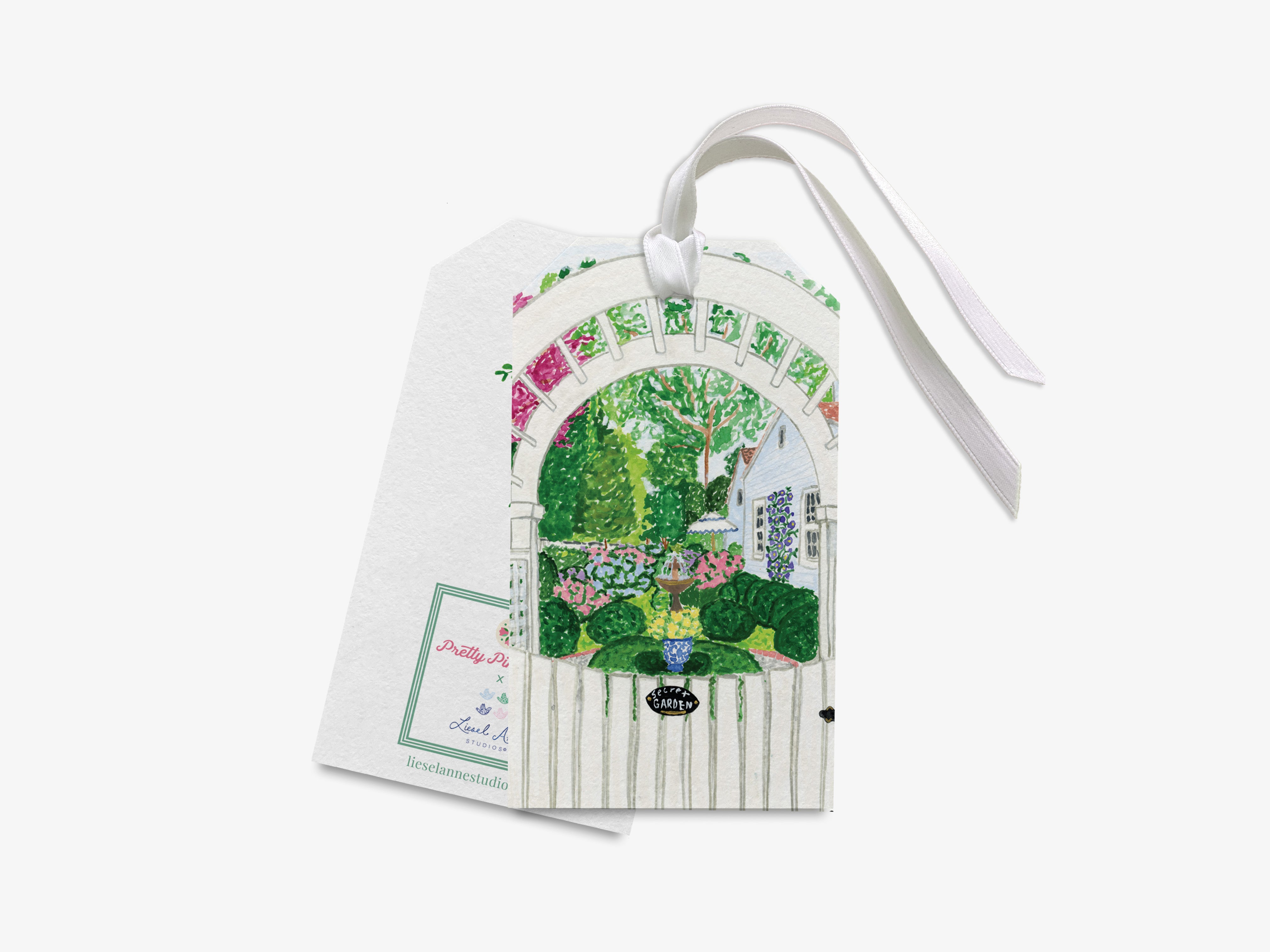 a white tag with a colorful illustration of a garden scene, including a white archway, flowers, and greenery.