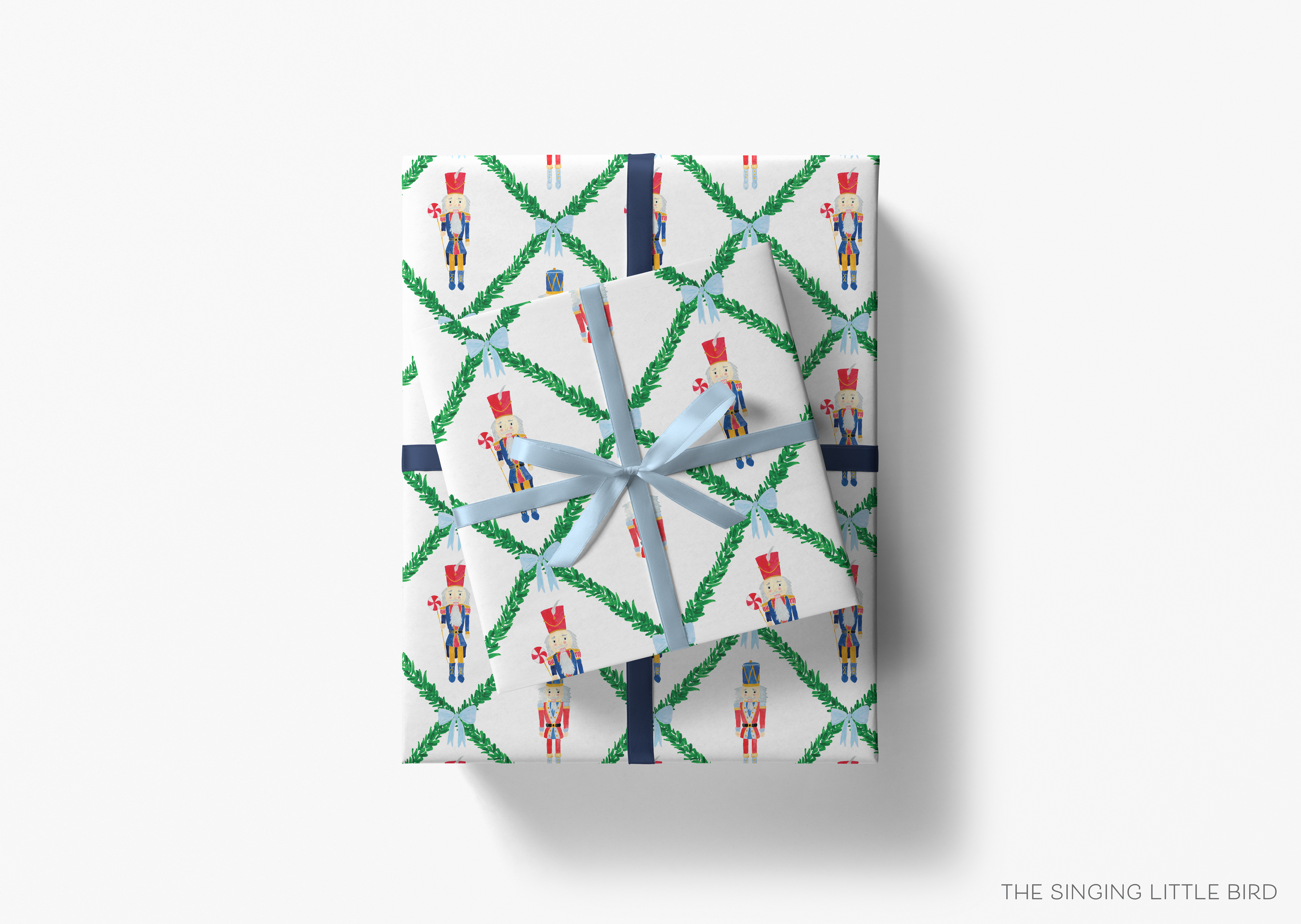A gift box wrapped in a patterned wrapping paper with nutcracker figures and green leaves.