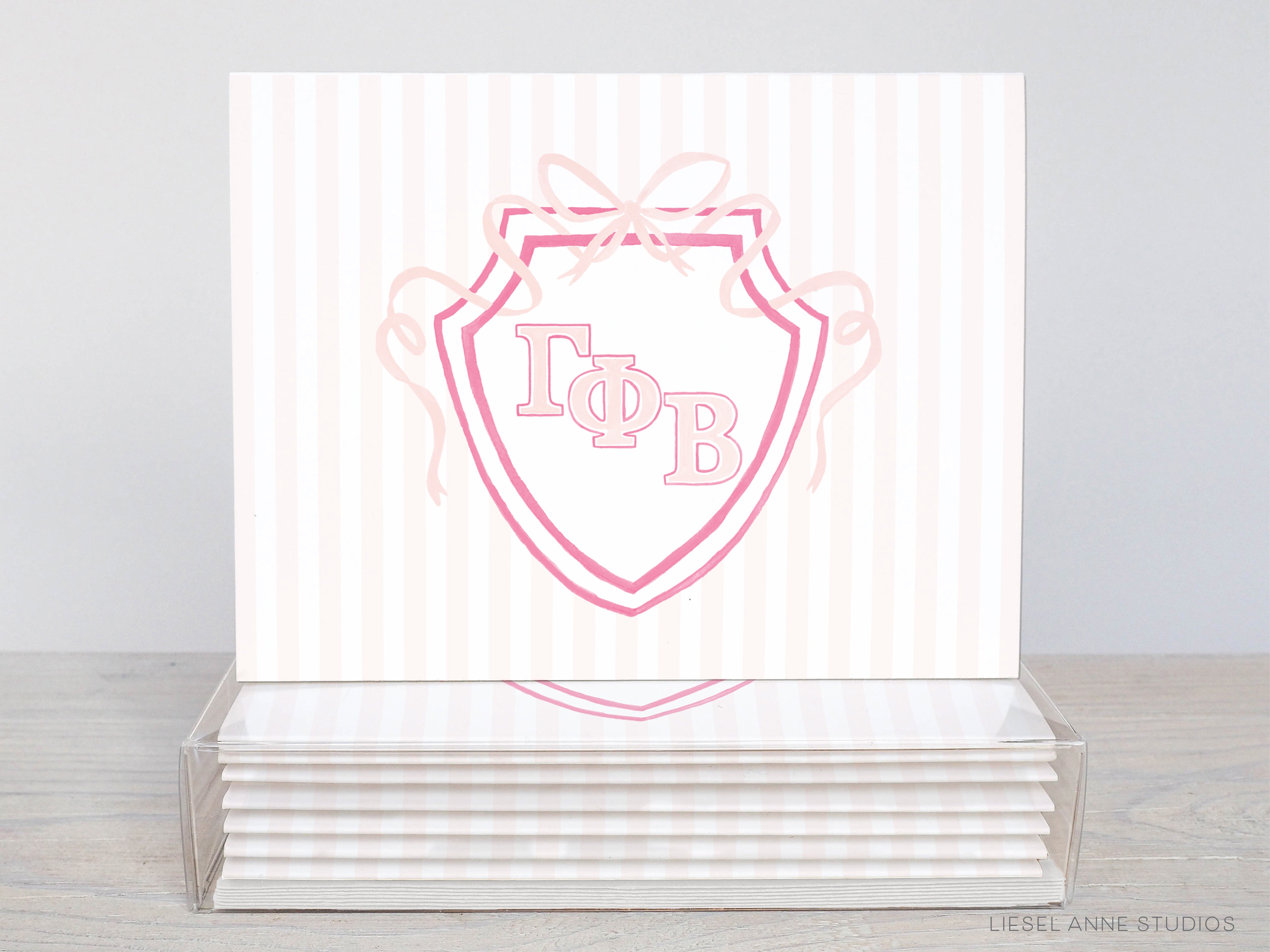 A stack of white greeting cards with a pink and white shield-shaped design featuring the letters 'ΦΑΓΟΡΕΙΑ' (Phi Beta Delta) on them.
