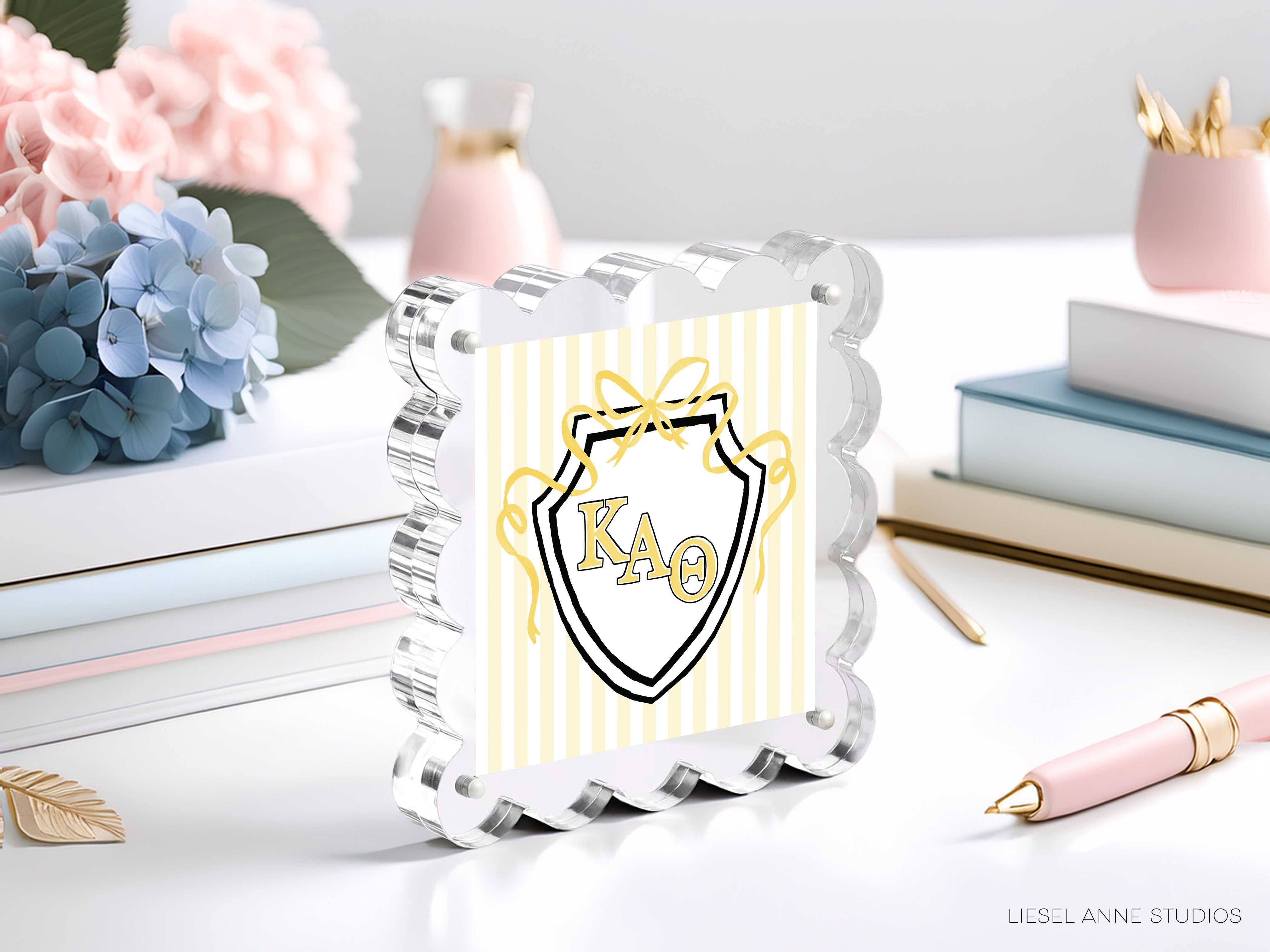 a clear glass frame with a decorative design, surrounded by various objects such as books, flowers, and a pen.
