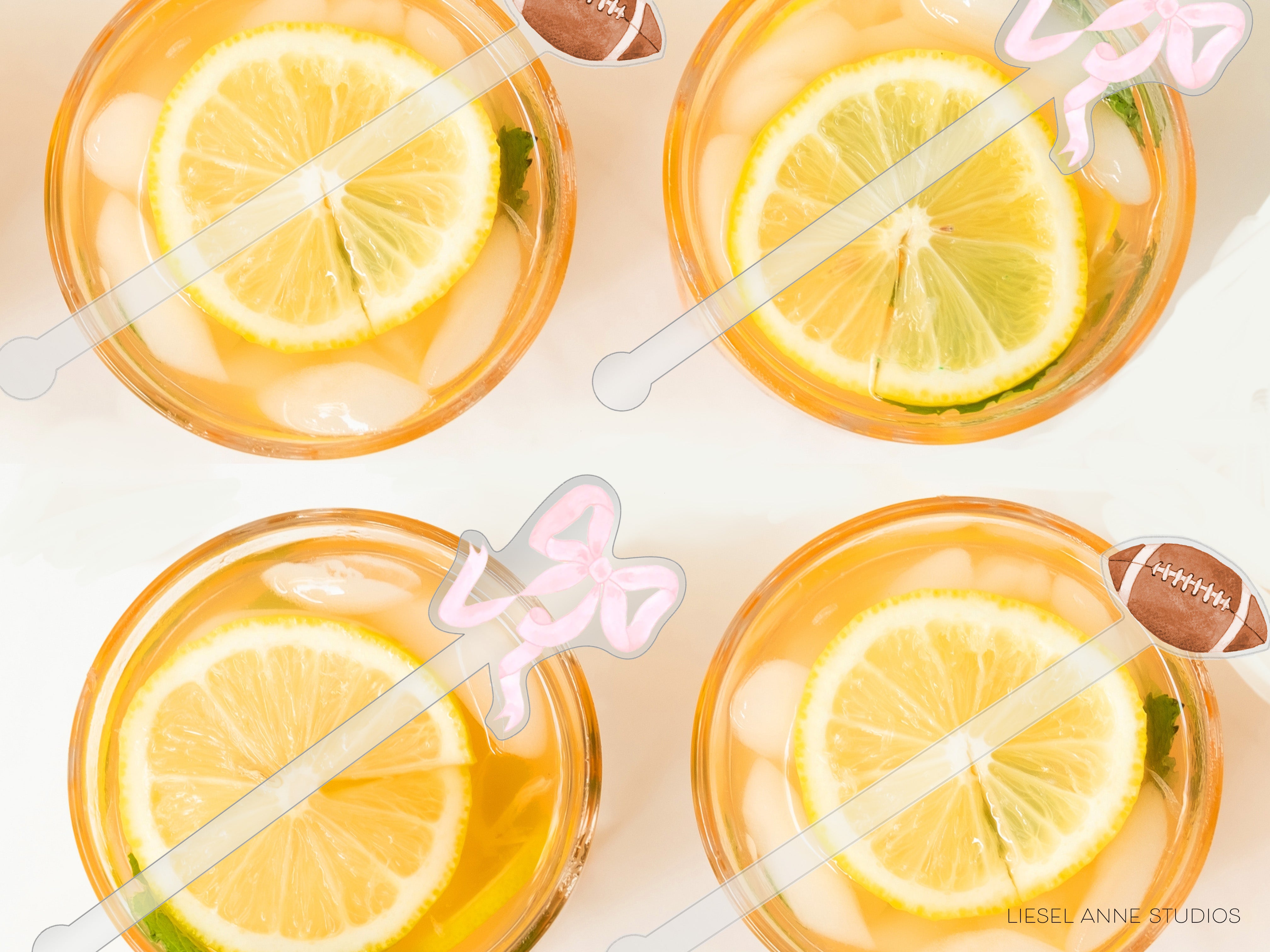 four glasses filled with a yellow liquid, each containing a slice of lemon and a football-shaped straw.
