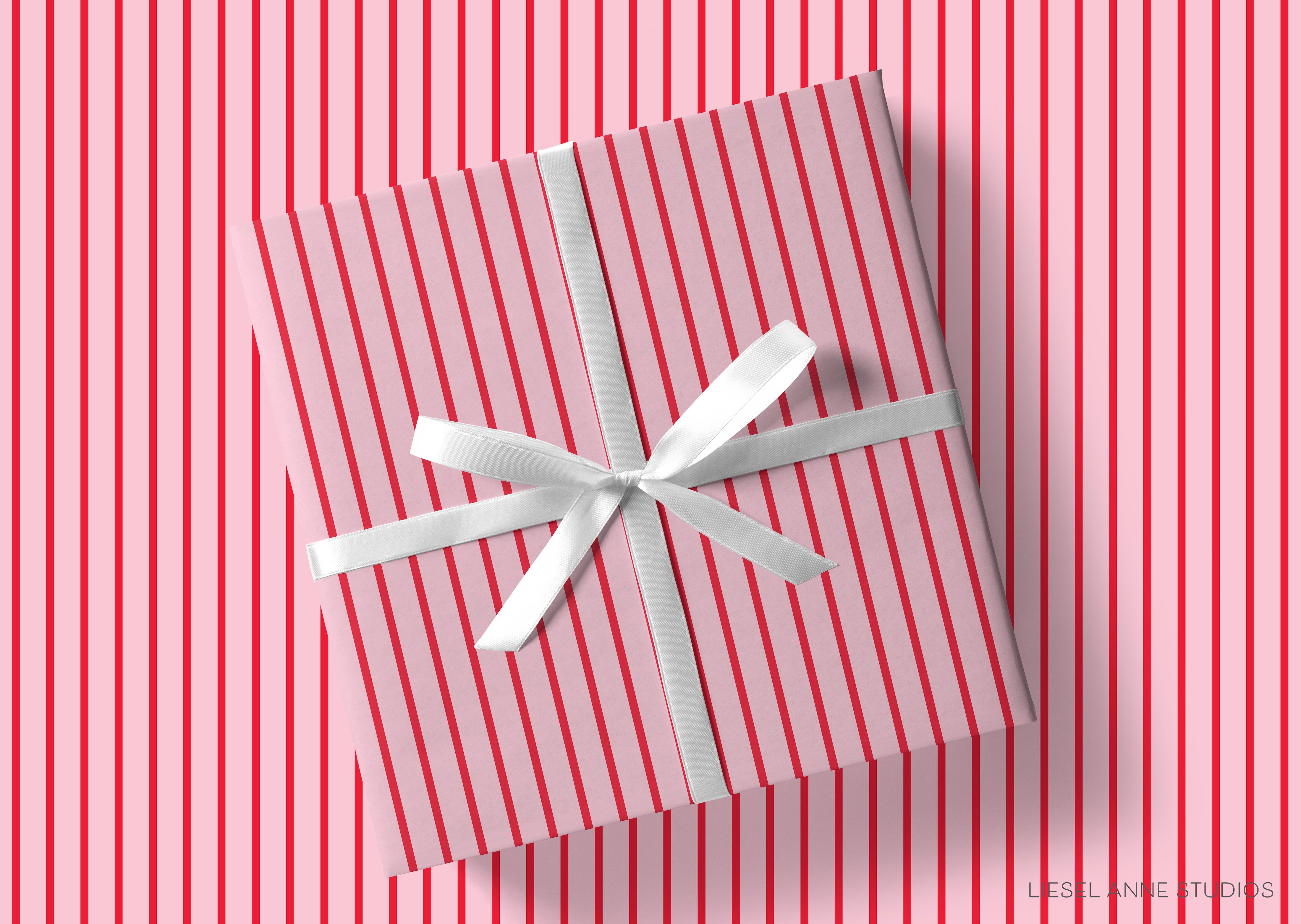 A gift box with a white ribbon tied around it, placed on a background of red and white striped patterns.