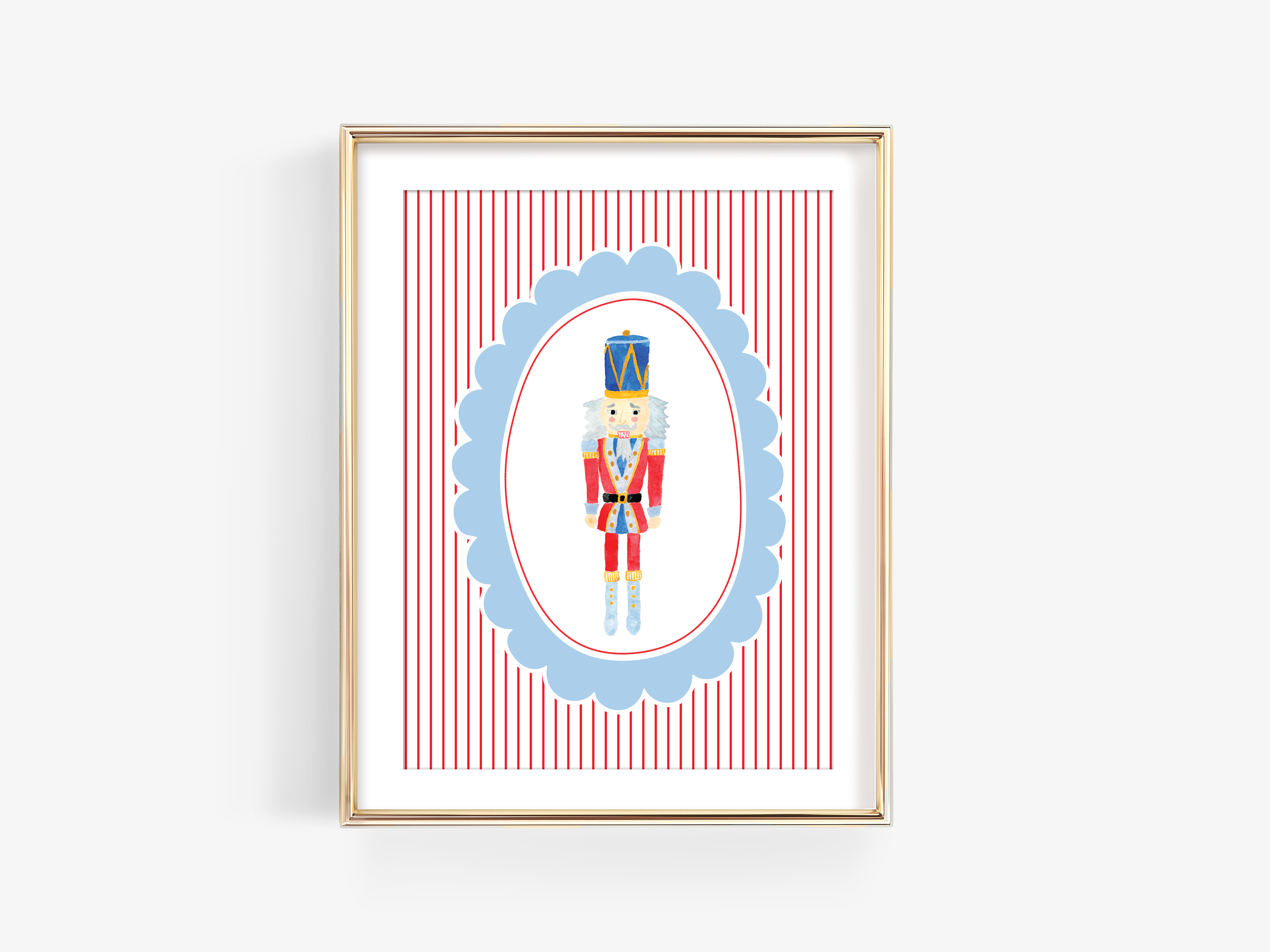 A framed illustration of a nutcracker figure wearing a red and blue outfit, standing in the center of a blue oval frame with red and white striped background.