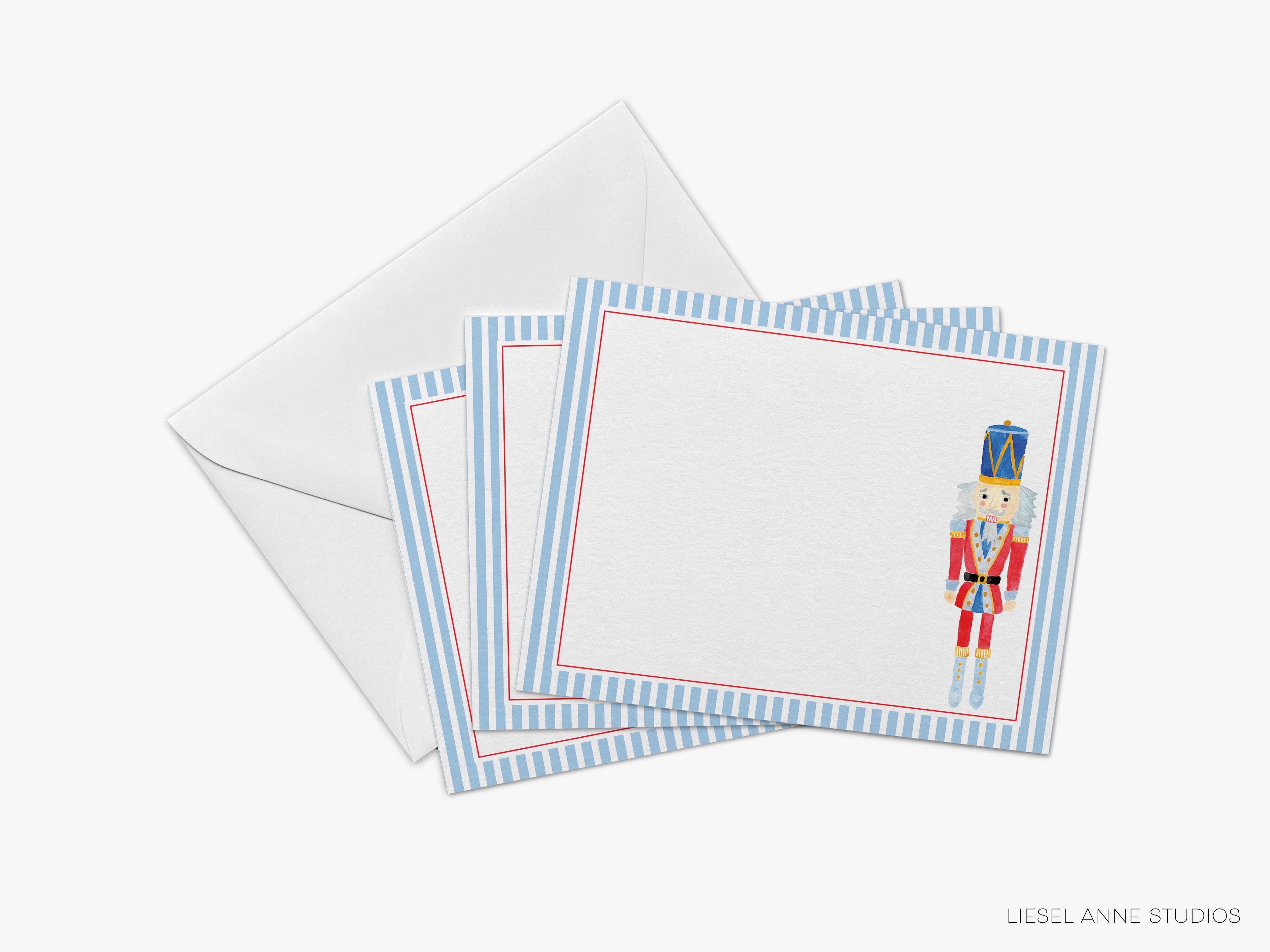 A set of four blue and white greeting cards with a nutcracker illustration on the front, placed on top of an envelope.