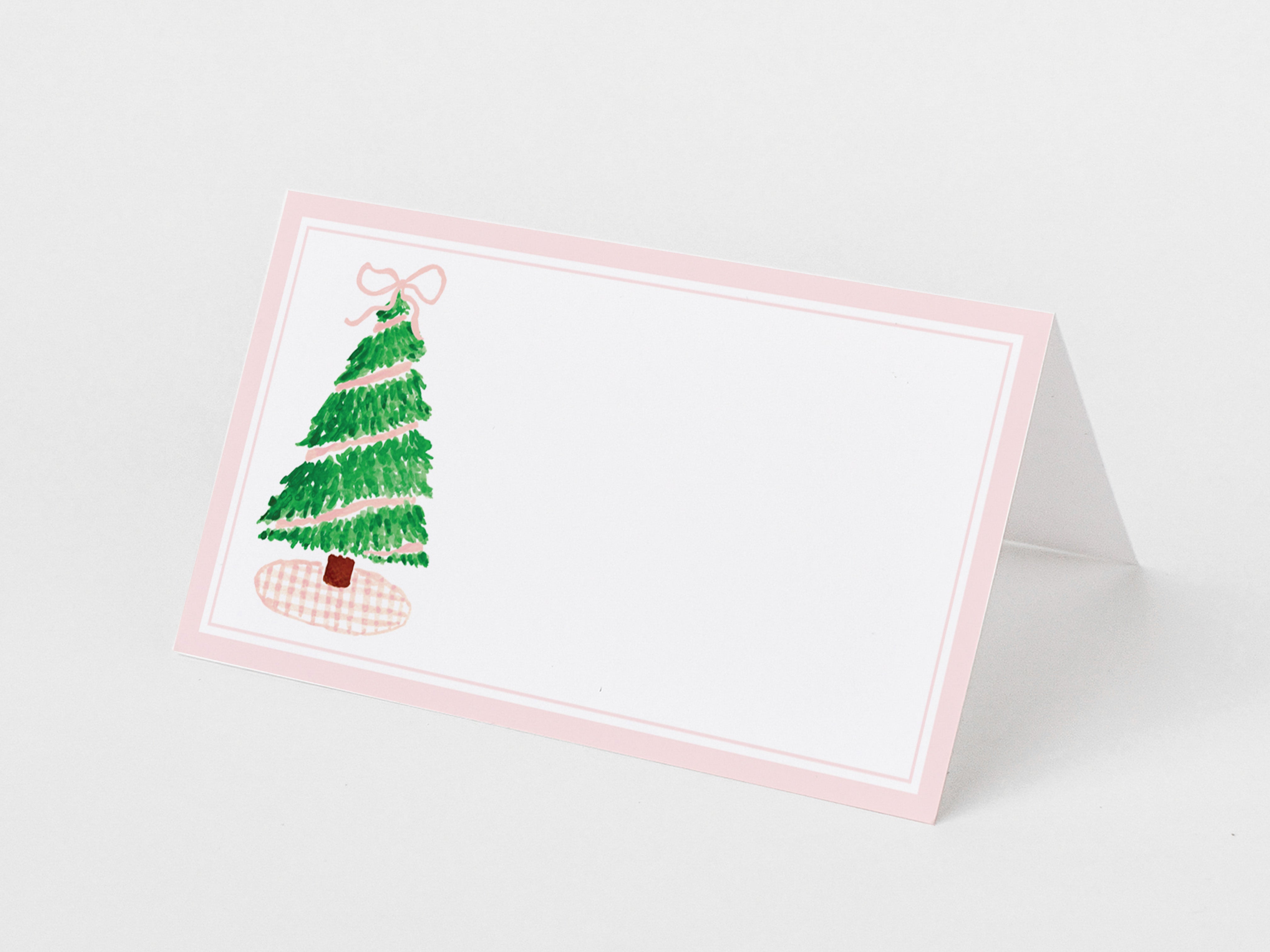 A pink and white card with a green Christmas tree illustration on it.