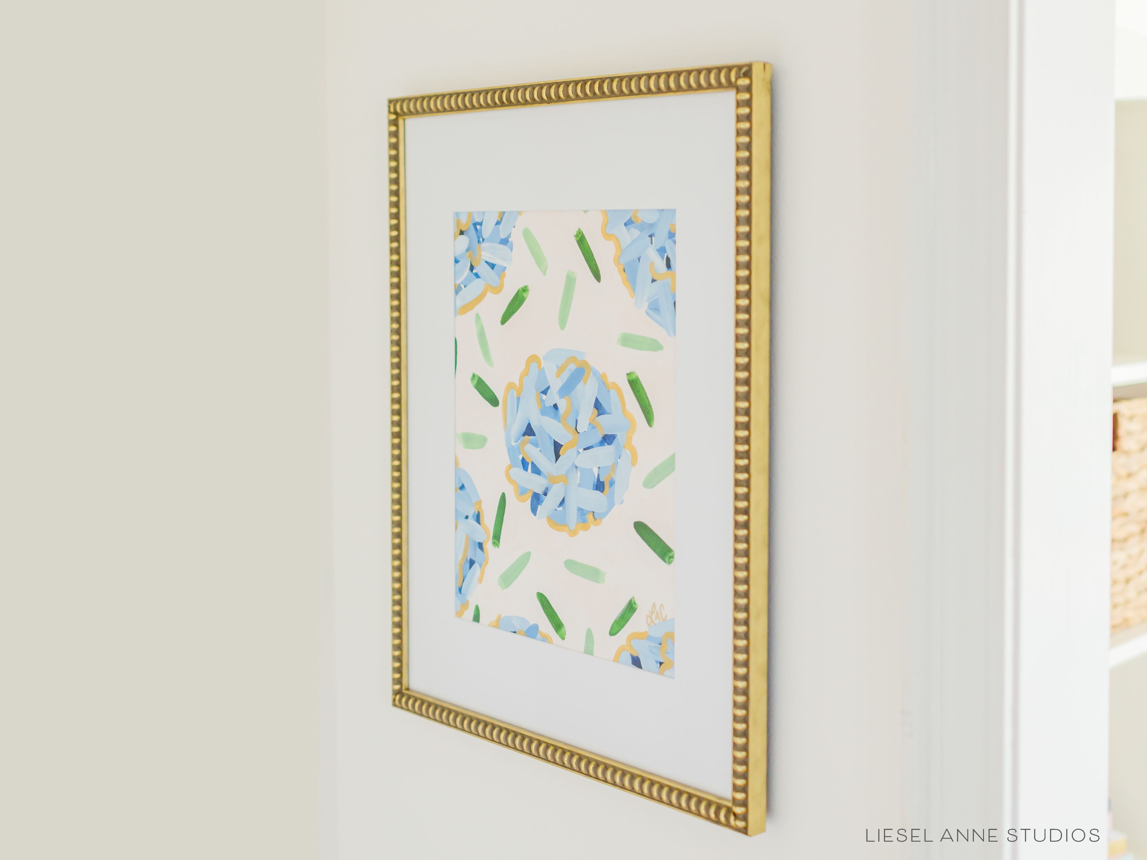 Golden Hydrangea | Blush & Blue VII-Original artwork measures 11"x14" | Hand-Painted with gouache on cold press watercolor paper | Matted and framed in gold wood frame sized 16"x20" | Glare-resistant glass | Hanging hardware included | Features our signature Golden Hydrangea design with a pale pink base, blue hydrangeas and shimmery gold accents | Initialed in gold by the Liesel Anne (the artist) on the front and signed and dated on the back.-The Singing Little Bird