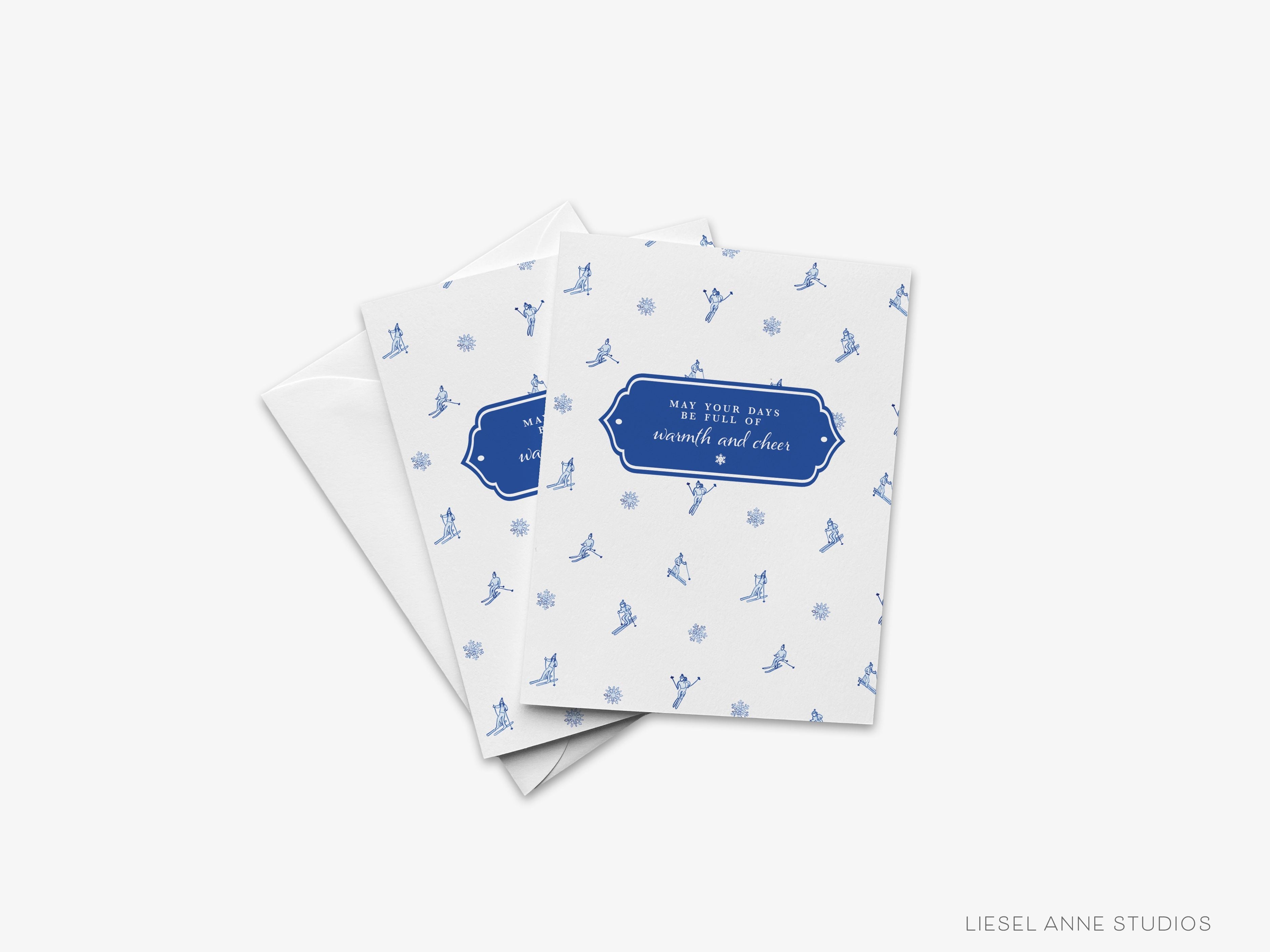 Holiday Warmth & Cheer Skier Greeting Card-These folded greeting cards are 4.25x5.5 and feature our hand-painted blue and white skiers, printed in the USA on 100lb textured stock. They come with a White envelope and make a great Holiday card for the snowflake lover in your life.-The Singing Little Bird