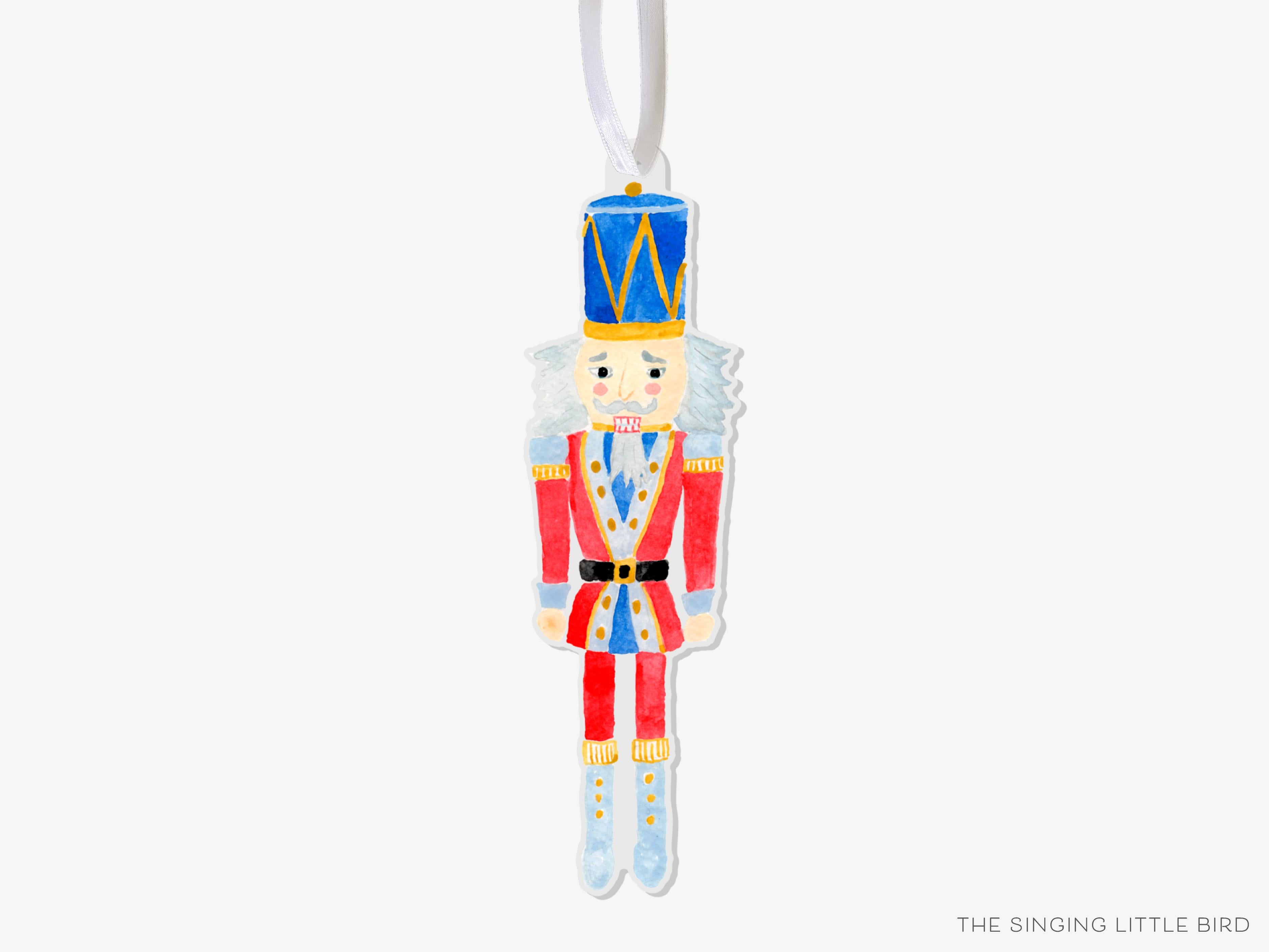 Nutcracker Acrylic Ornament-These acrylic ornaments feature our hand-painted watercolor Nutcracker. They include a white silk ribbon and measure approximately 4" on its longest side, making a great addition to your Christmas tree or gift for the Nutcracker lover in your life.-The Singing Little Bird
