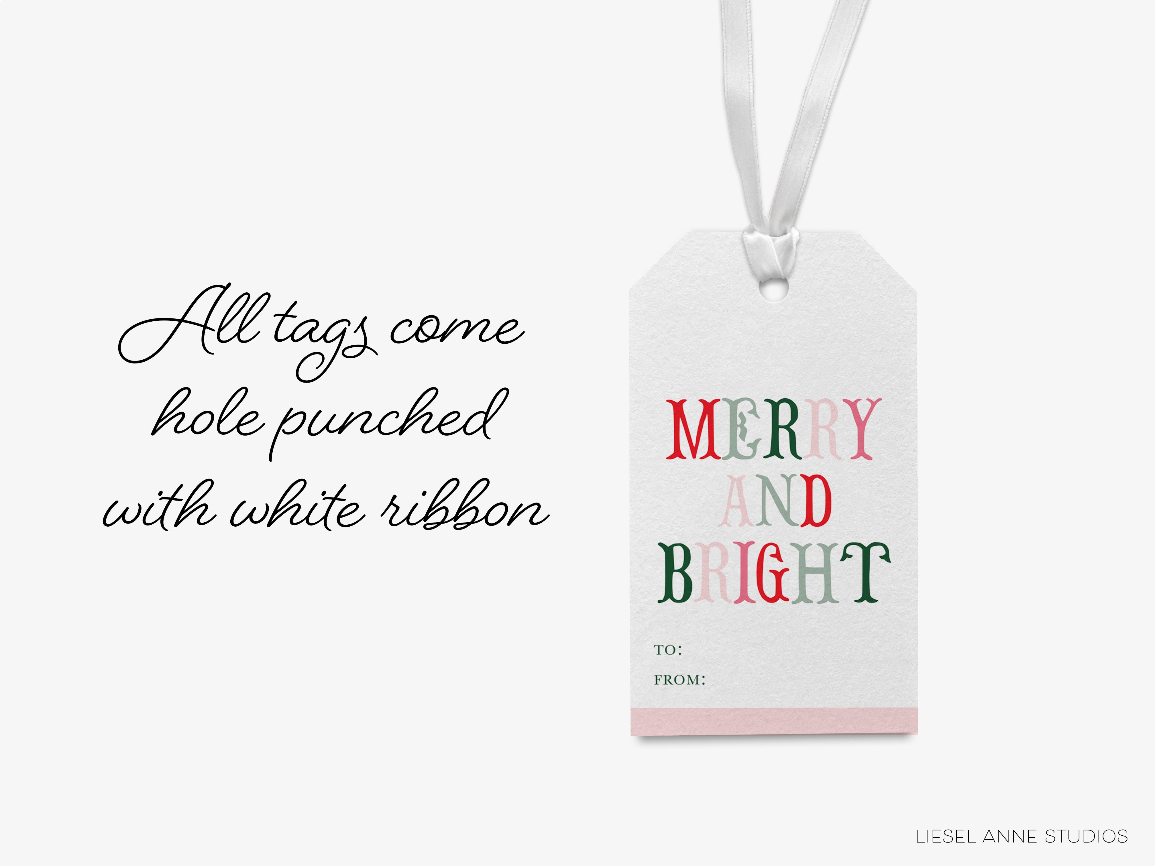 a white tag with the text "MERRY AND BRIGHT" and a ribbon, along with a caption that reads "All tags come hole punched with white ribbon".