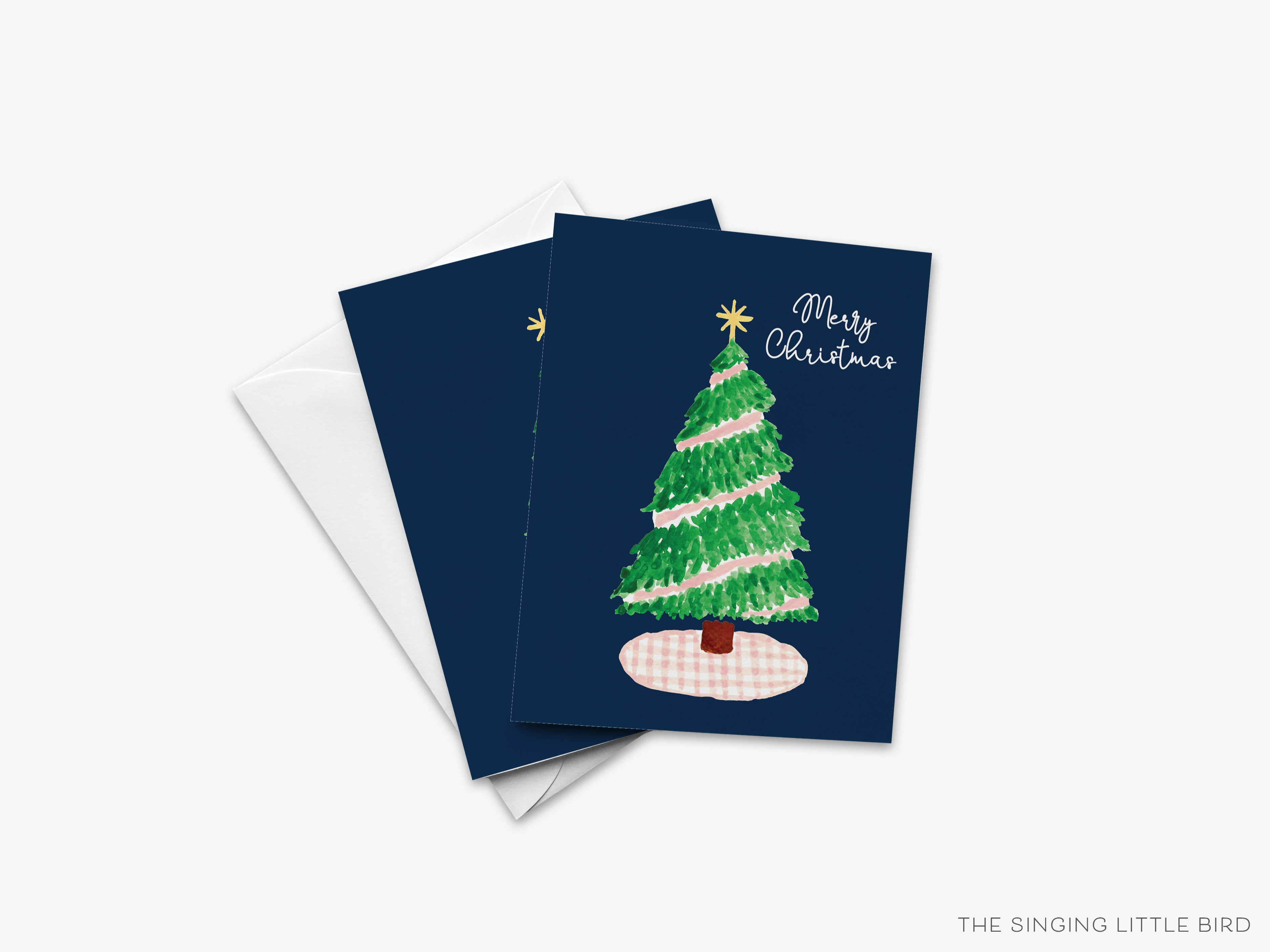 A Christmas card with a green tree on a white background, along with the text "Merry Christmas" written on it.