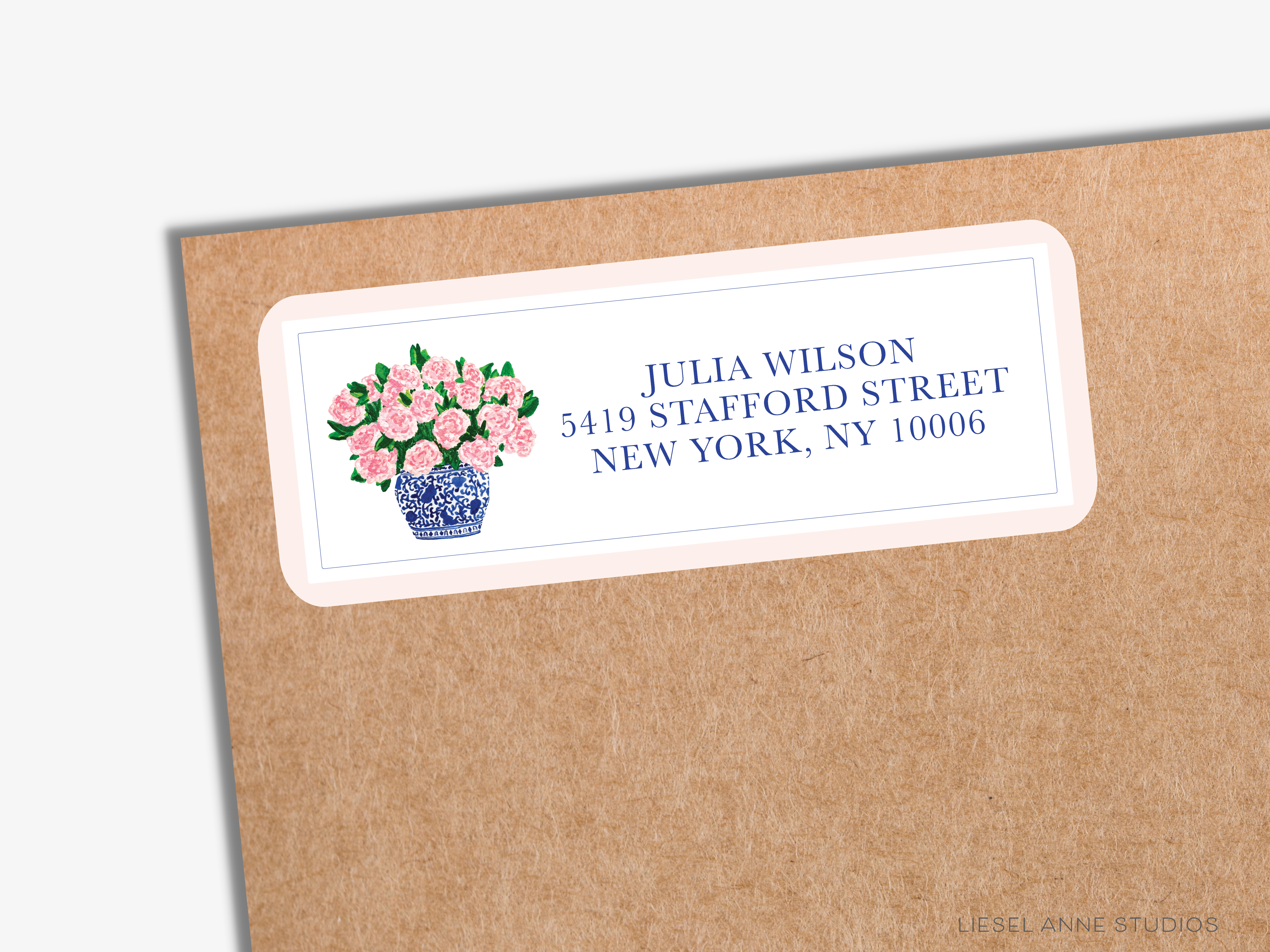 A brown envelope with a white label featuring a blue and white floral design and the address "JULIA WILSON 5419 STAFFORD STREET NEW YORK, NY 10006".