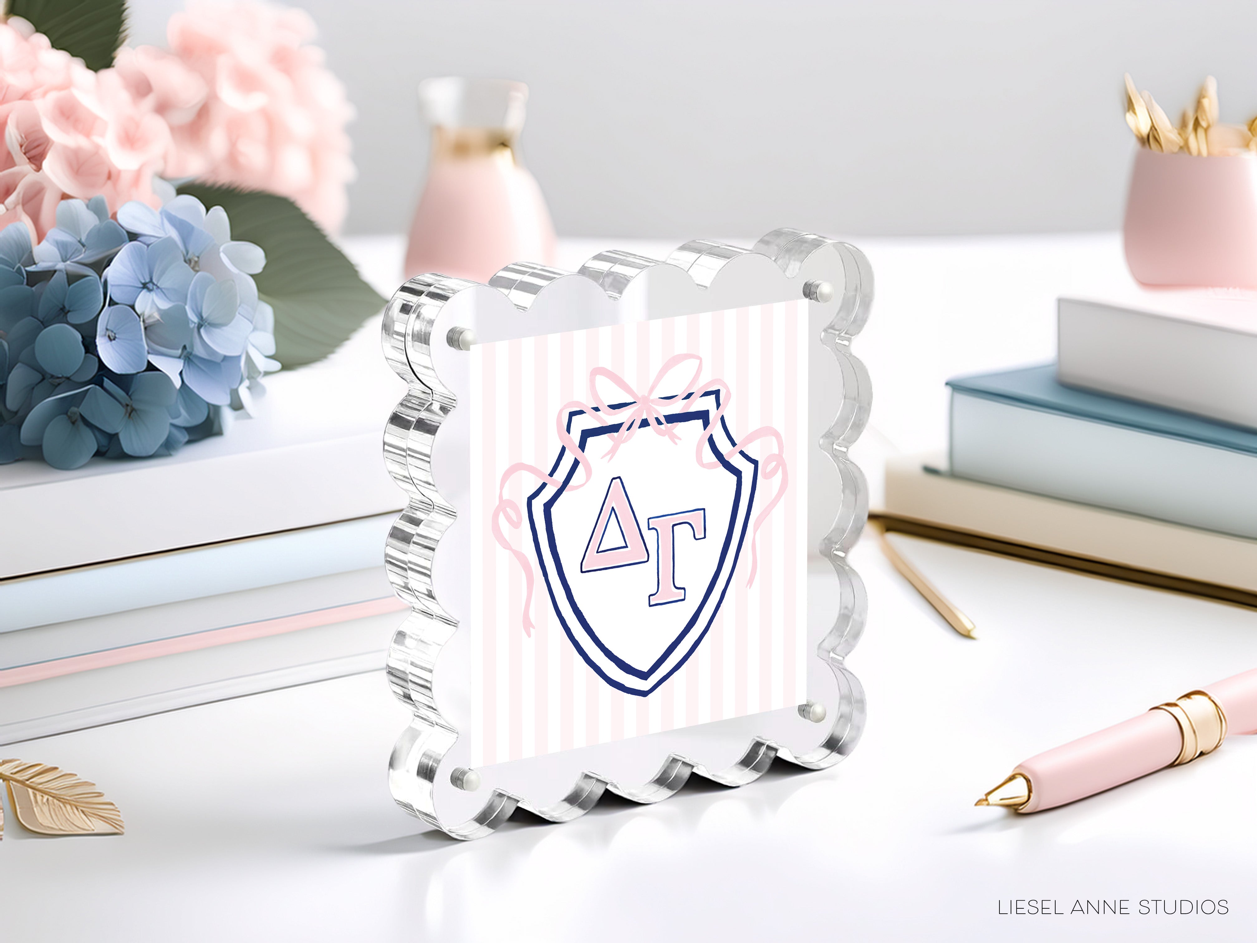 a decorative glass frame with a shield-shaped logo, surrounded by various office supplies and decorative items such as flowers and books.