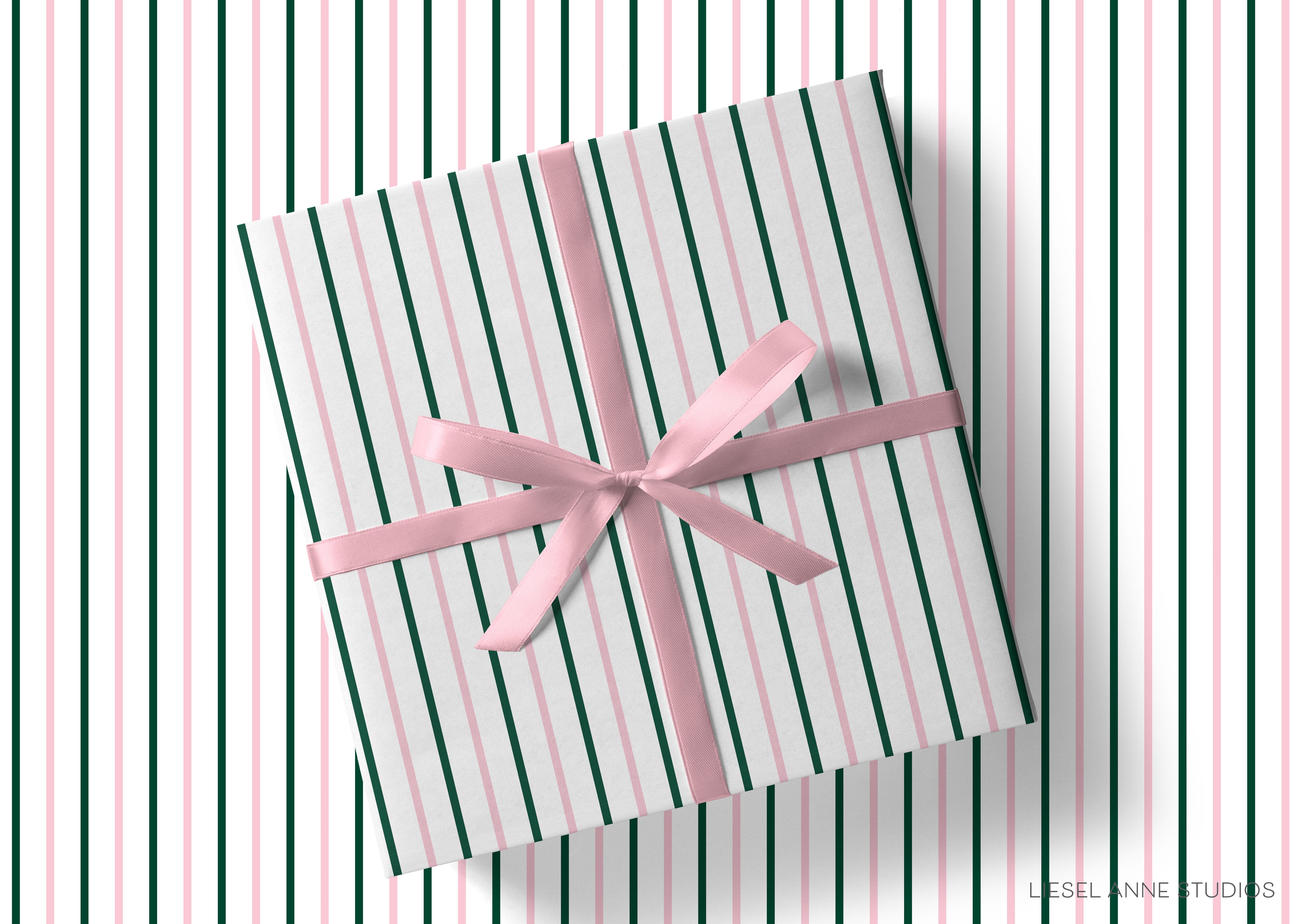 A gift wrapped in a striped paper with a pink ribbon tied around it, placed on a striped background.