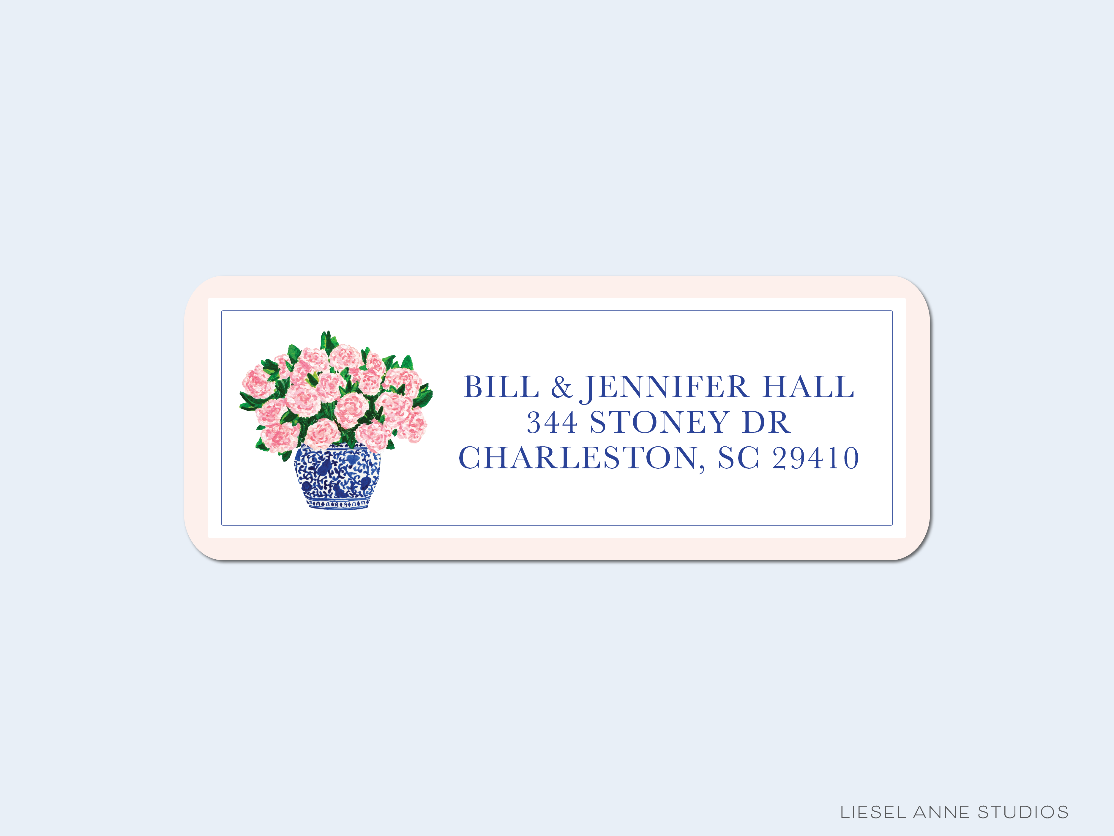 A rectangular address label with a floral design and text, including the name of the building and the street address.
