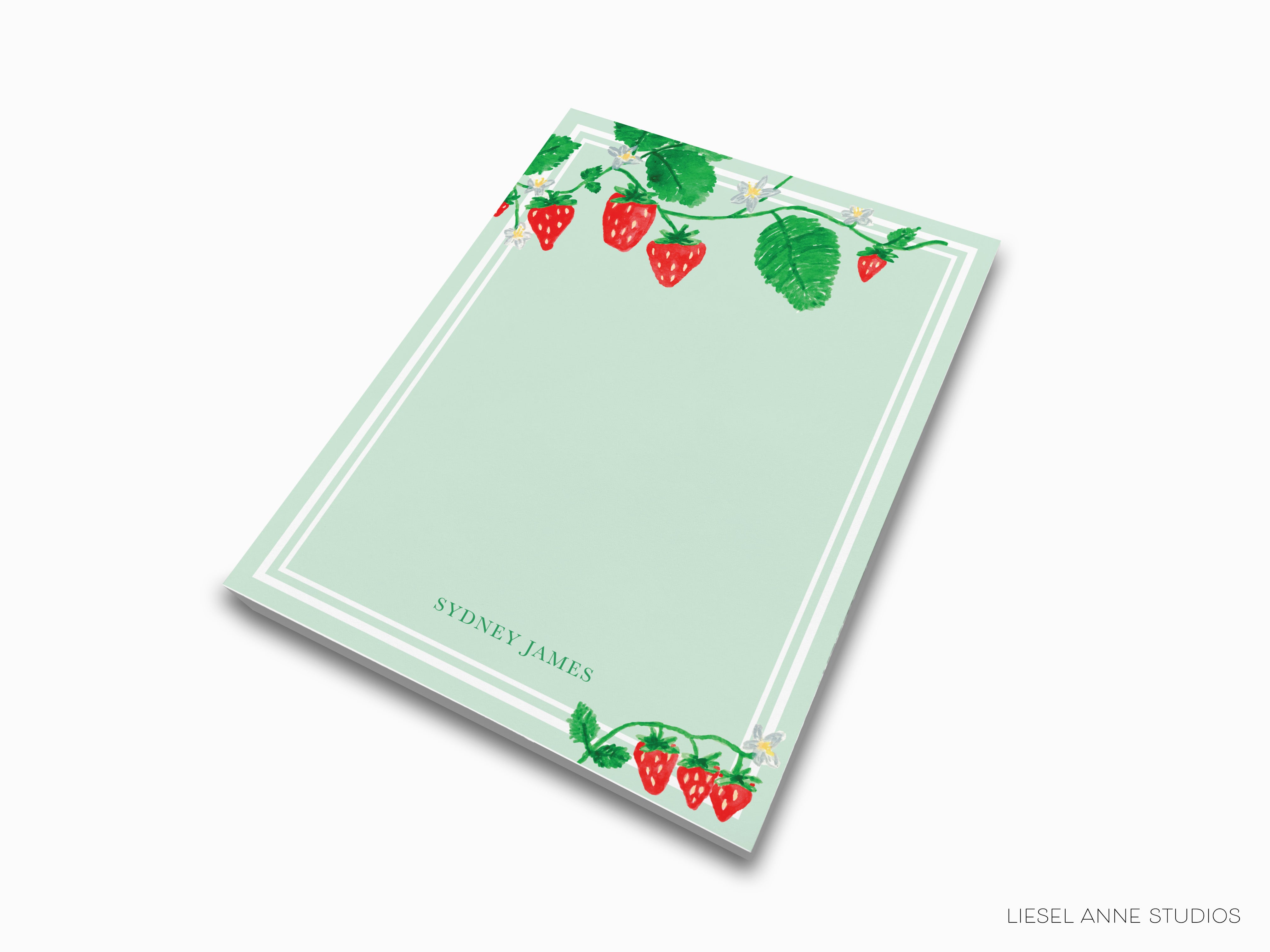 a notepad with strawberries and leaves on it