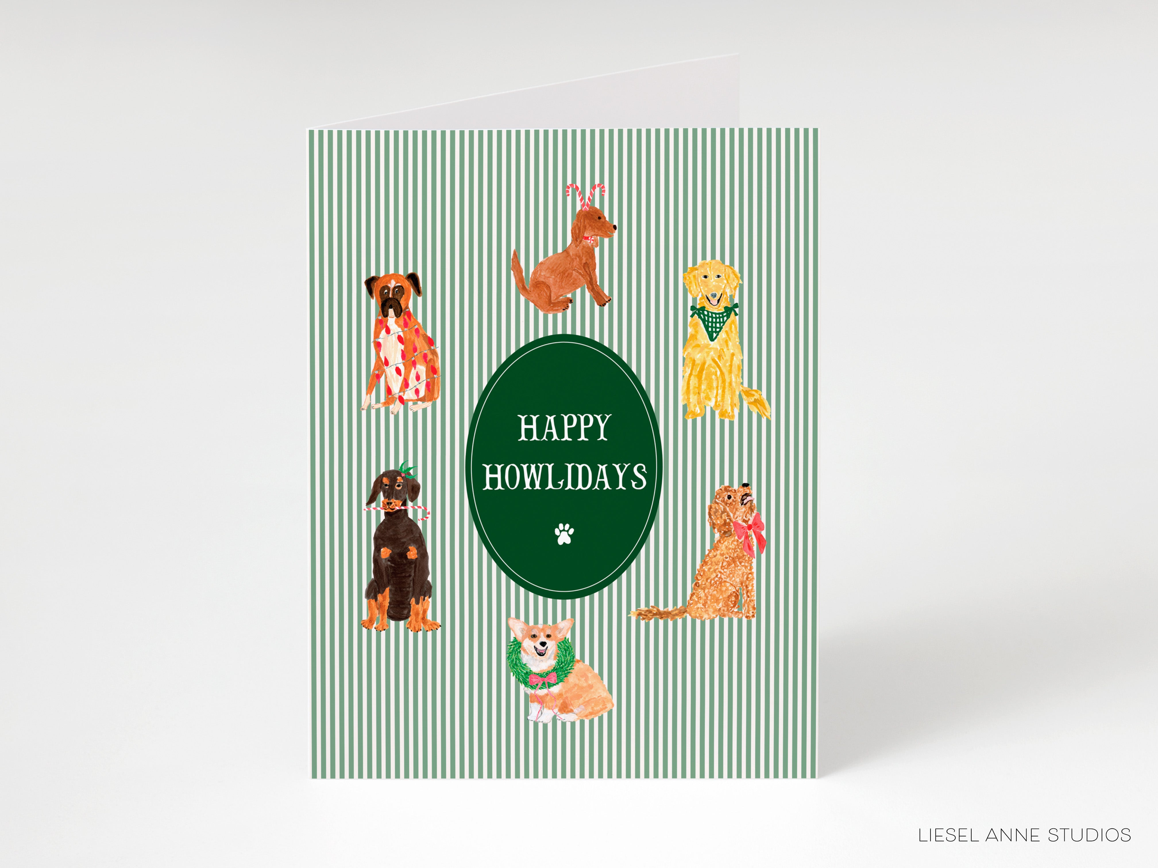 A greeting card featuring a green background with a white border and a central green circle containing illustrations of various dog breeds. The text "HAPPY HOWLIDAYS" is displayed in the center of the circle.