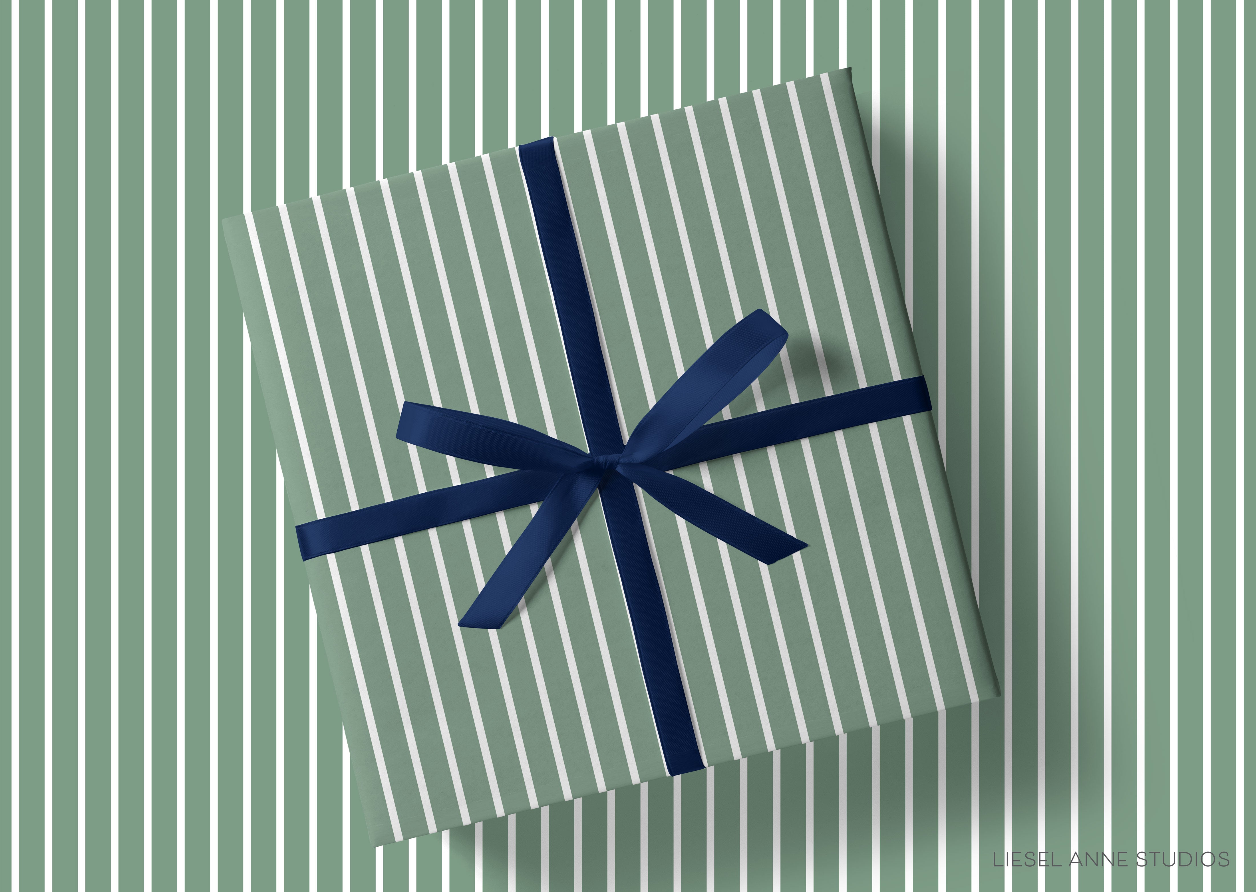 A gift box with a blue ribbon tied around it, placed on a background of green and white striped patterns.
