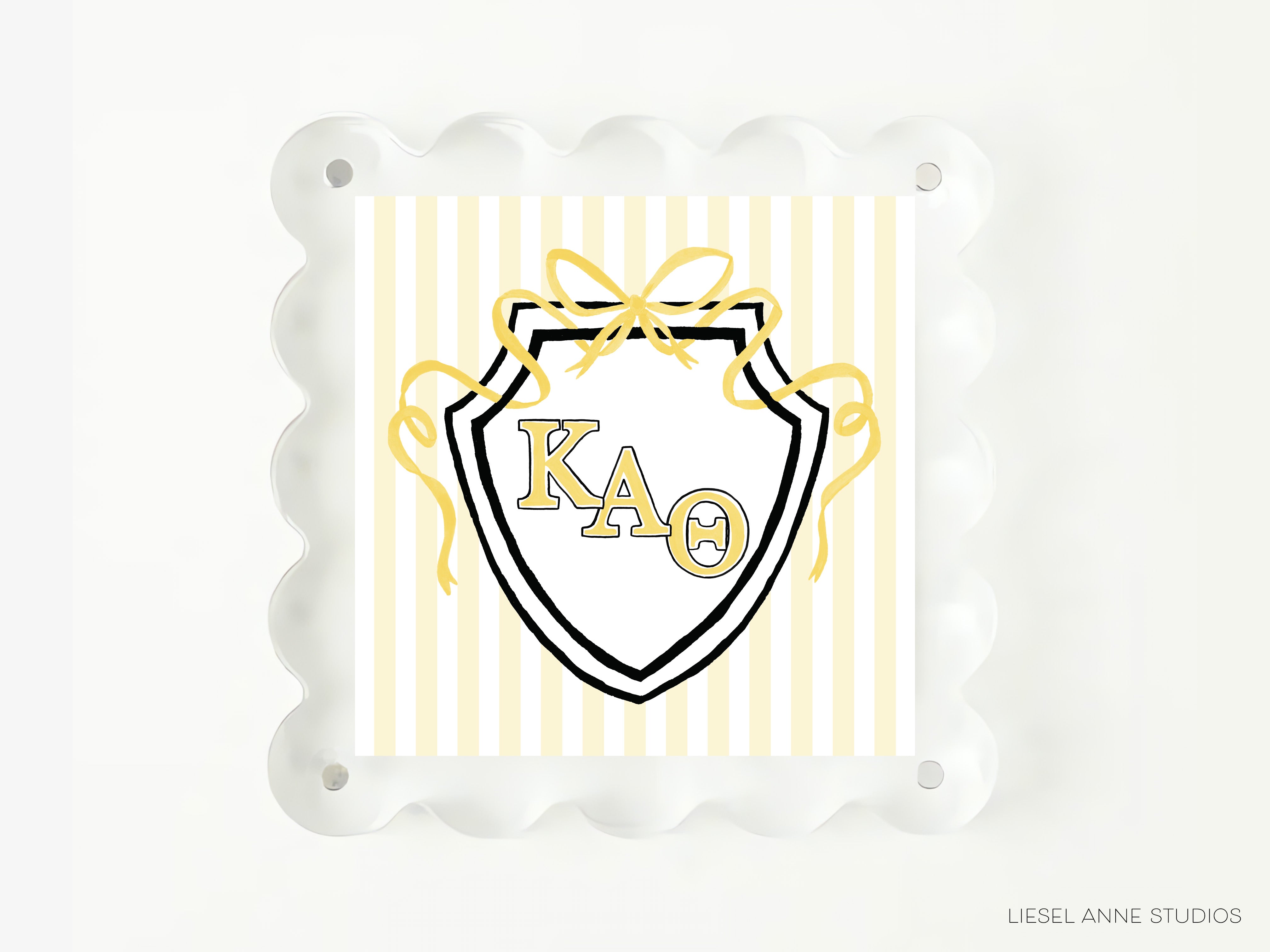 A shield-shaped graphic with the letters "KAQ" prominently displayed in the center, surrounded by a decorative border of yellow ribbons.
