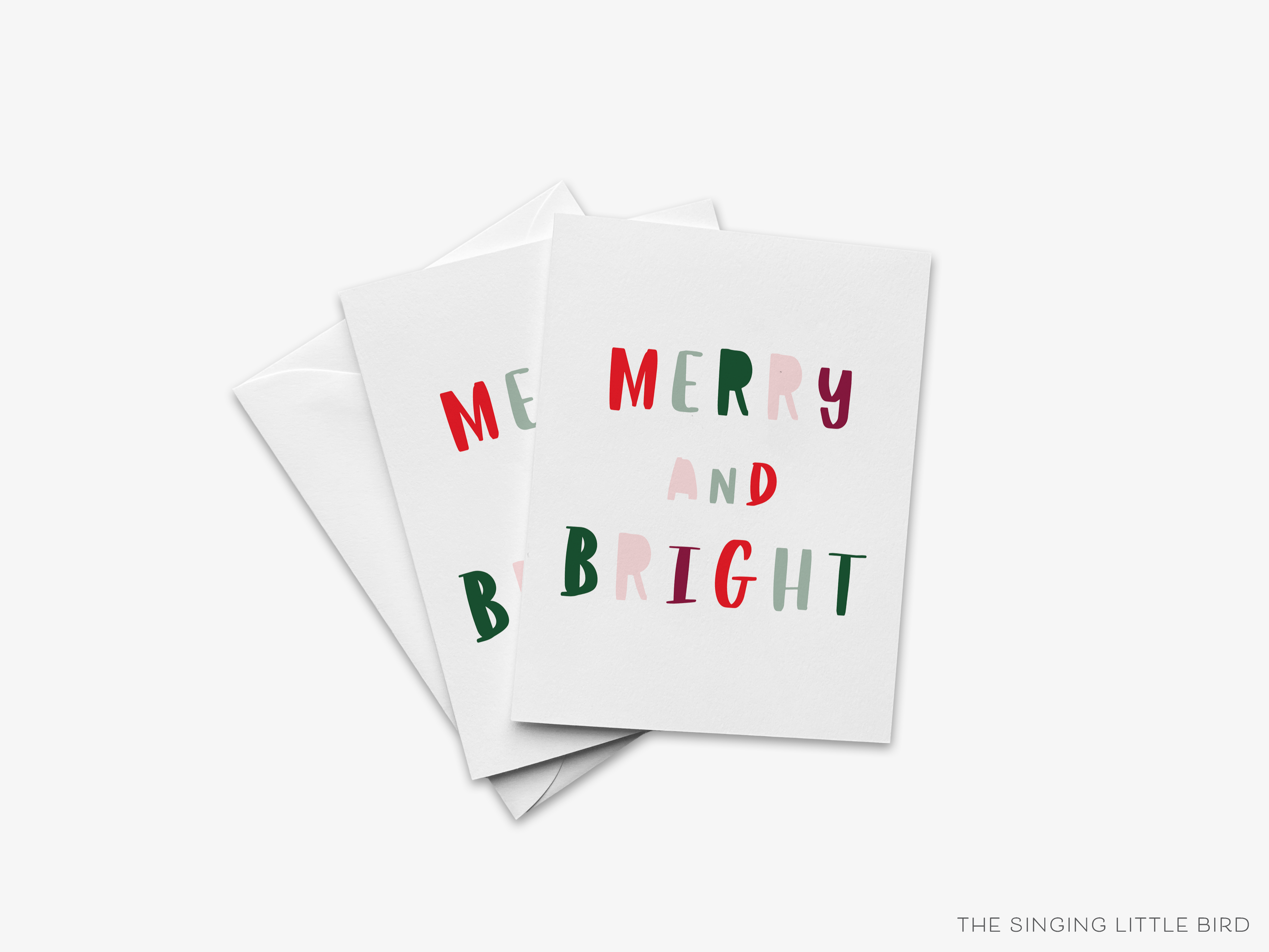 A stack of three white greeting cards with the text "MERRY AND BRIGHT" printed on them.