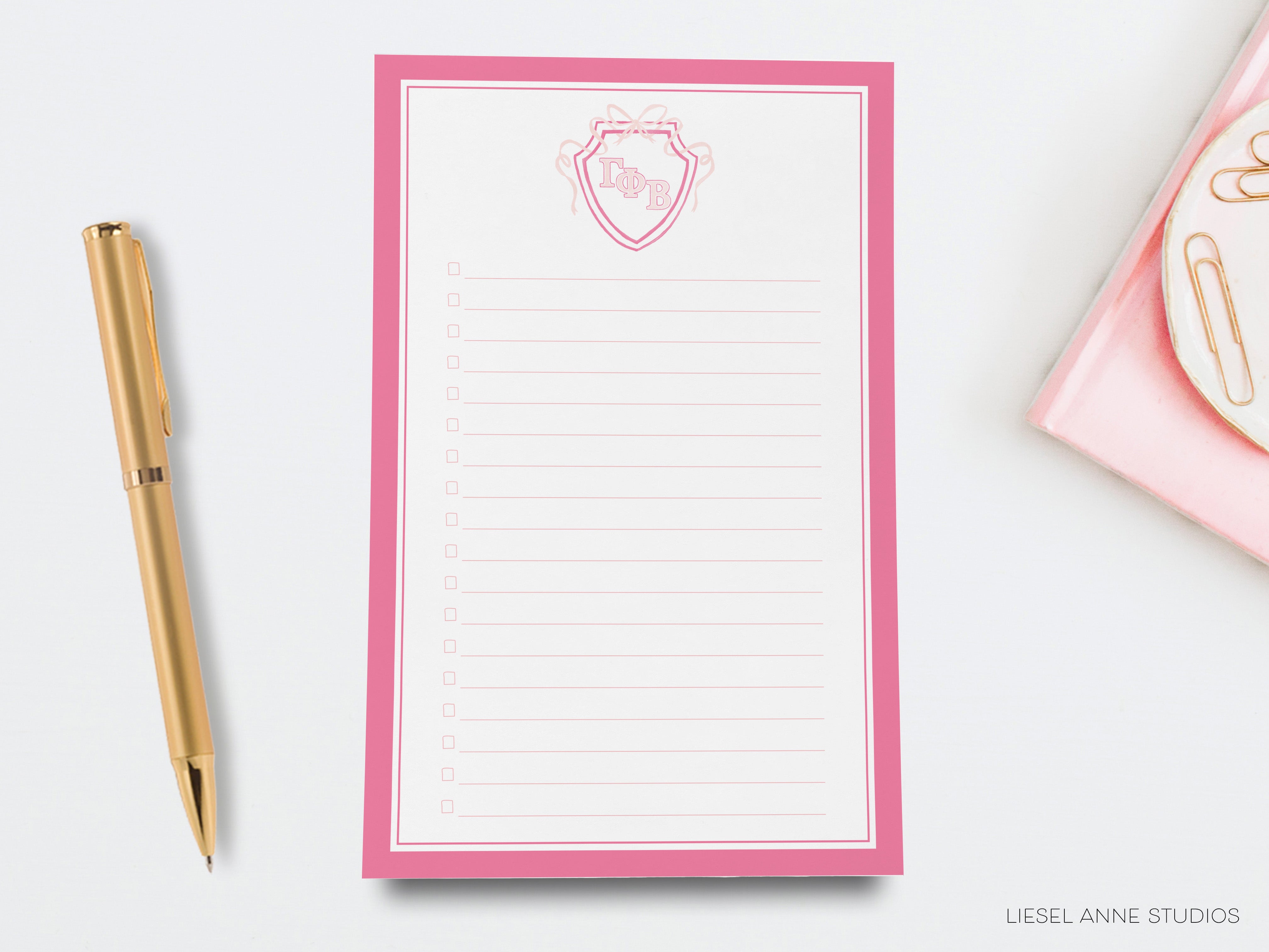 a notepad with a pink border and a pen next to it