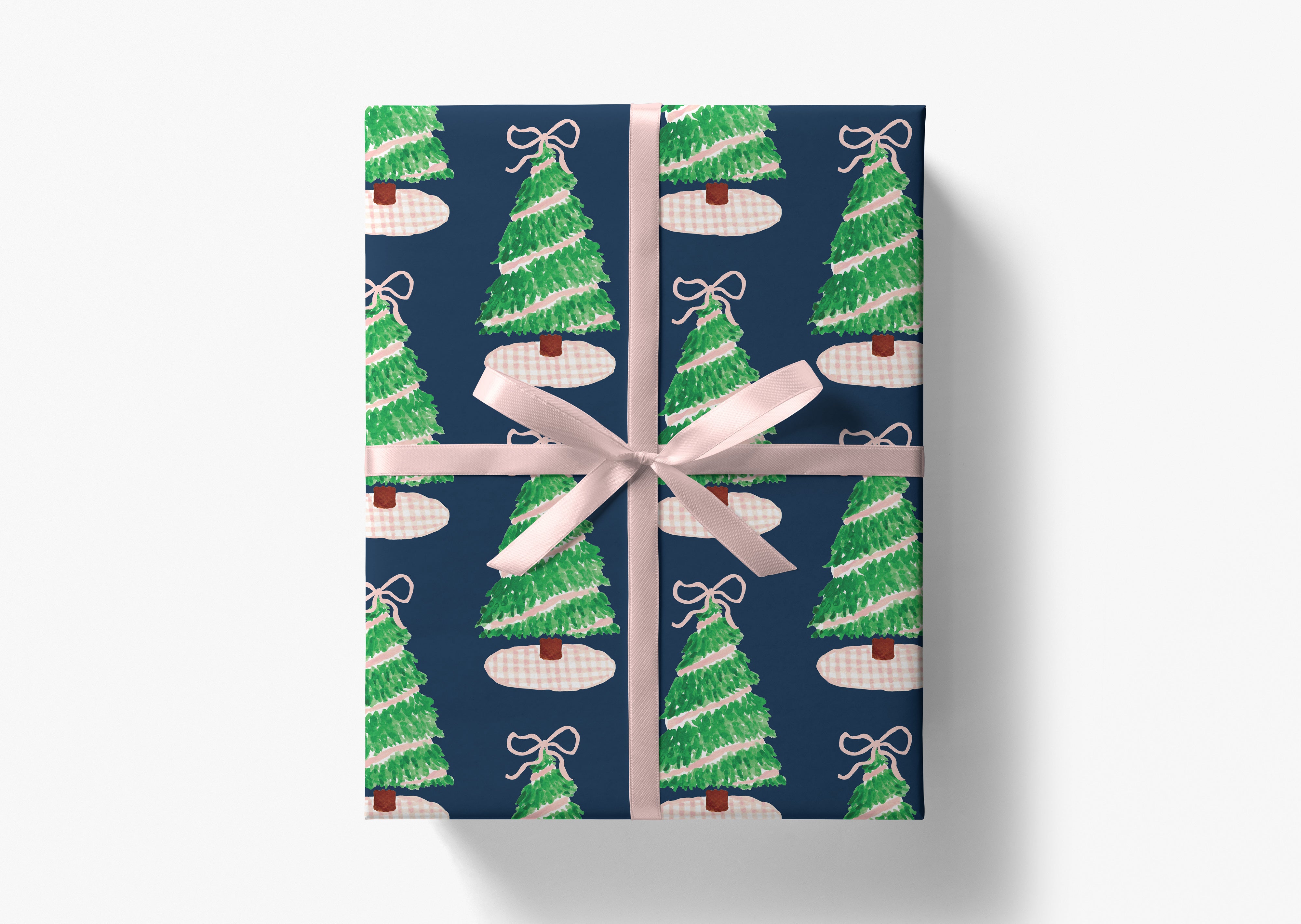 A gift box with a pattern of Christmas trees and a pink ribbon tied around it.