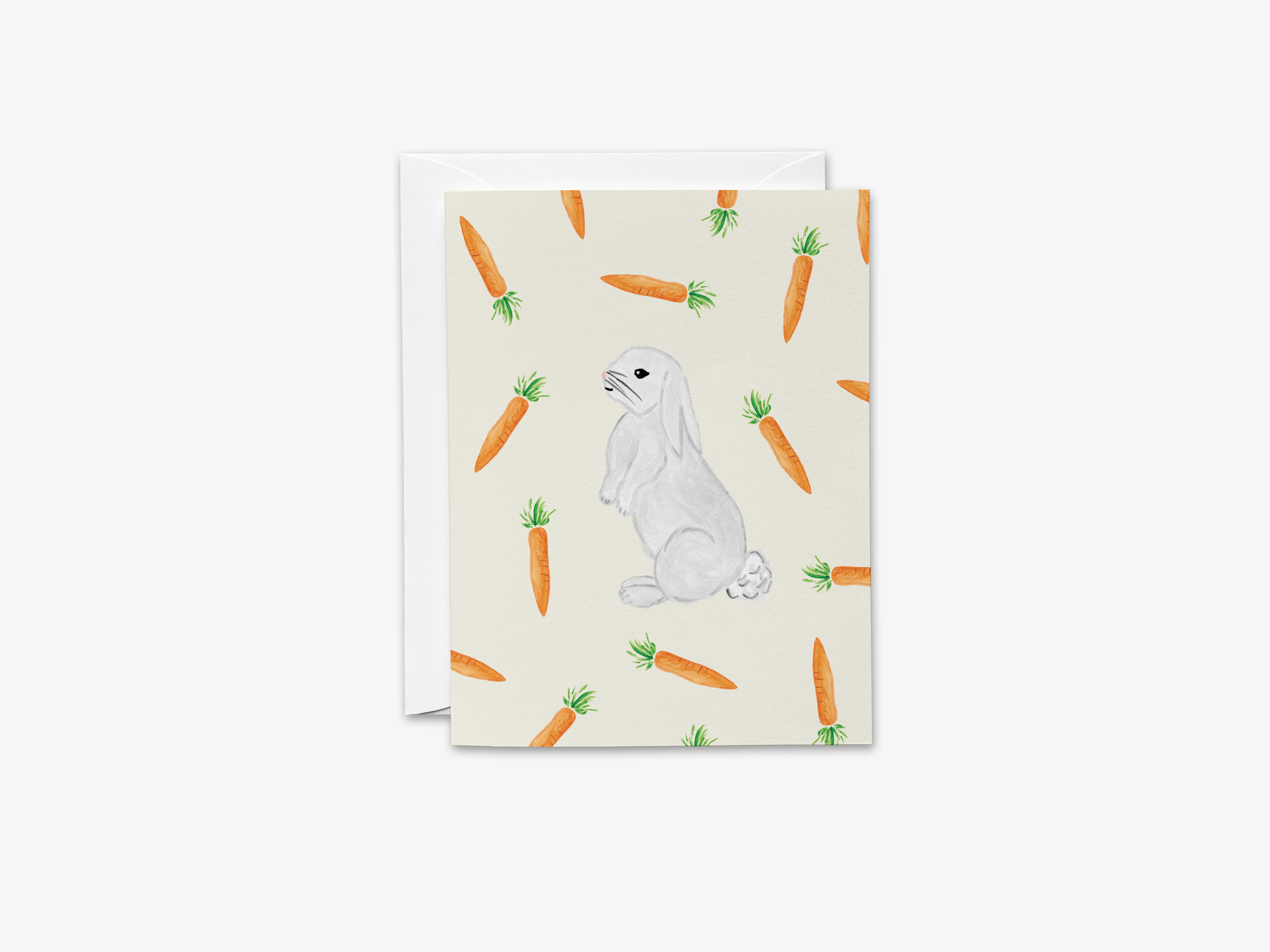 a white rabbit sitting amidst a pattern of orange carrots.