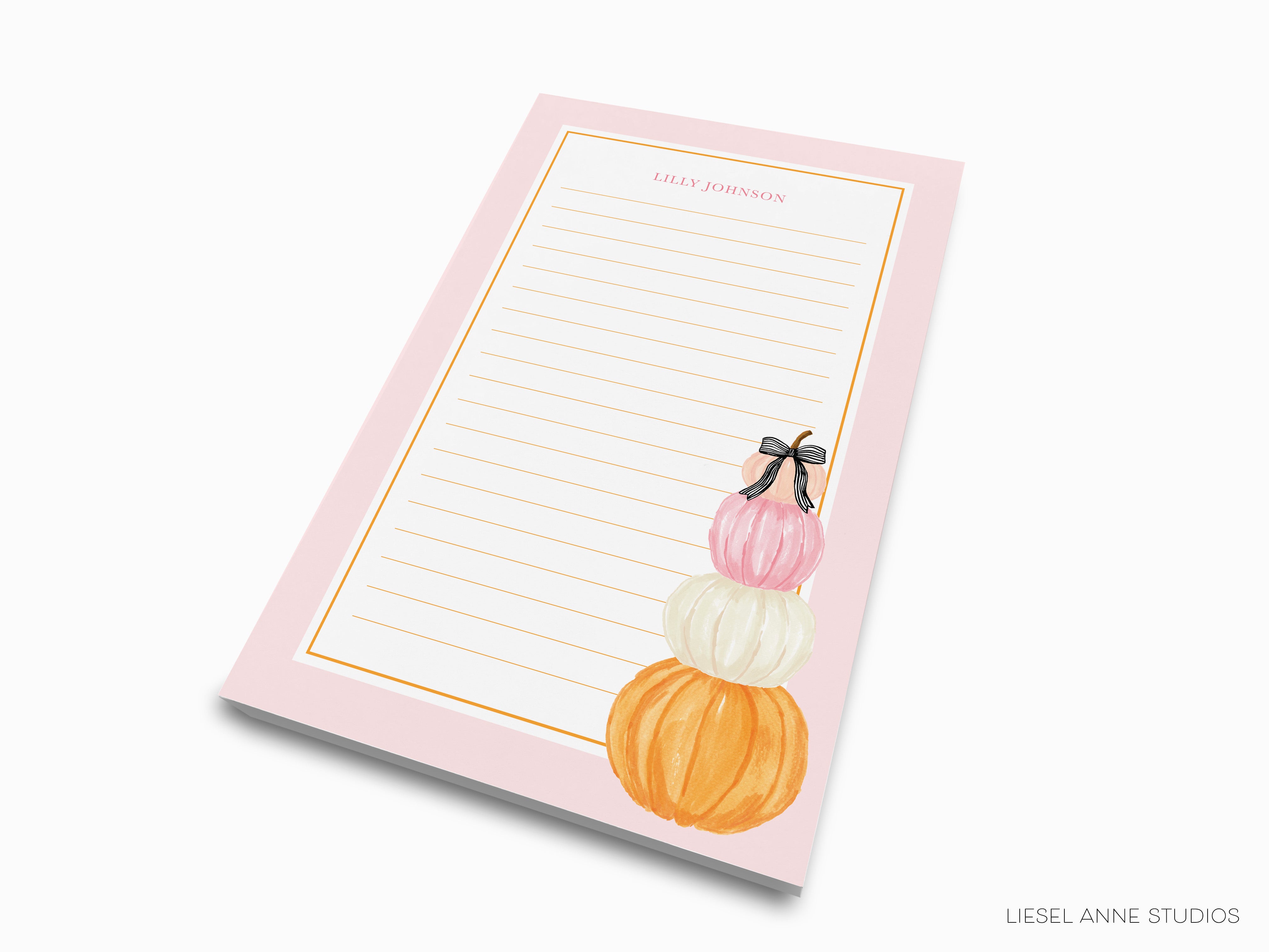 A pink lined notepad with a decorative design of three stacked pumpkins on the right side.