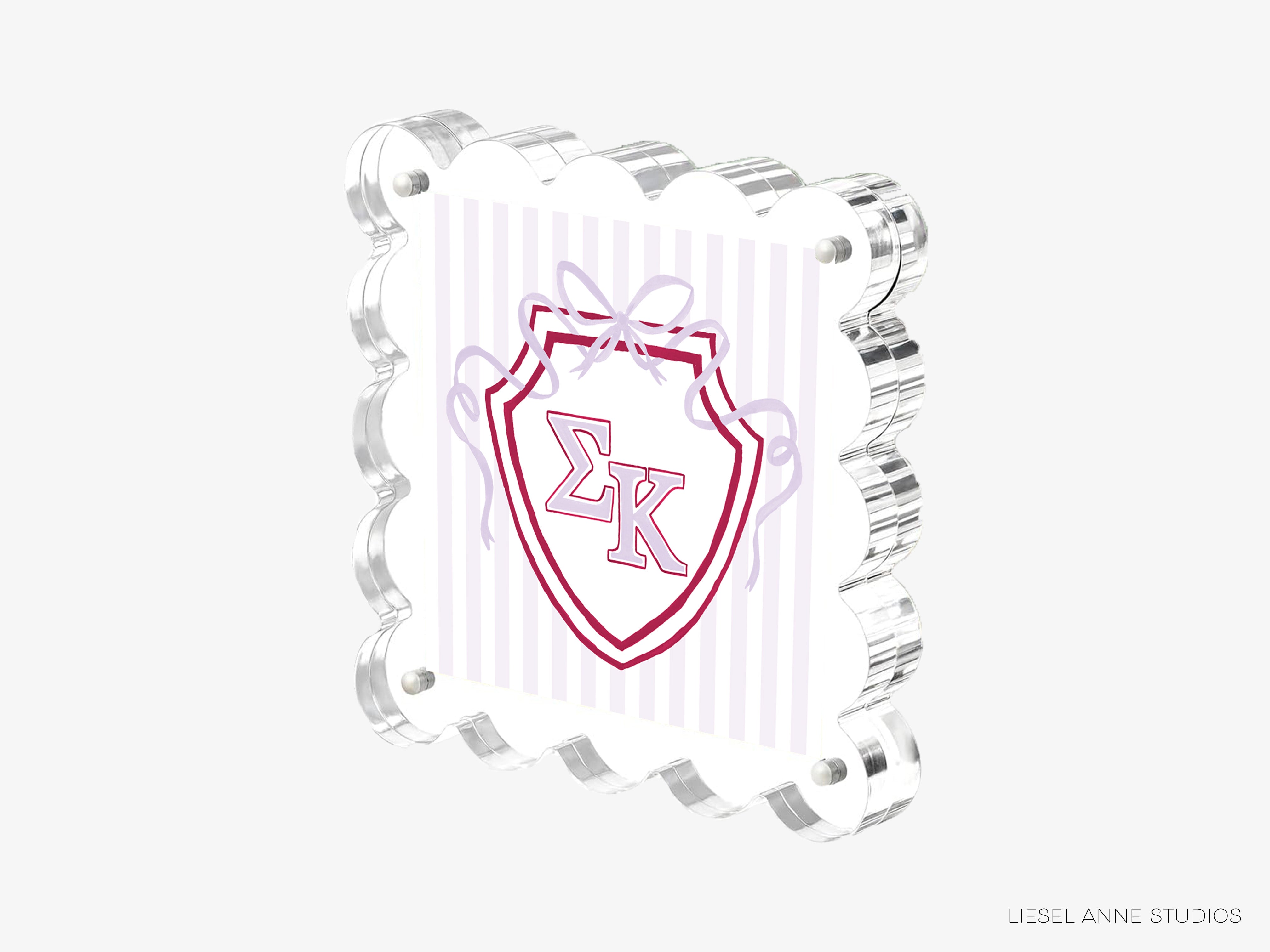a shield-shaped object with a red and white design, including a ribbon and the letters 'EK' prominently displayed.