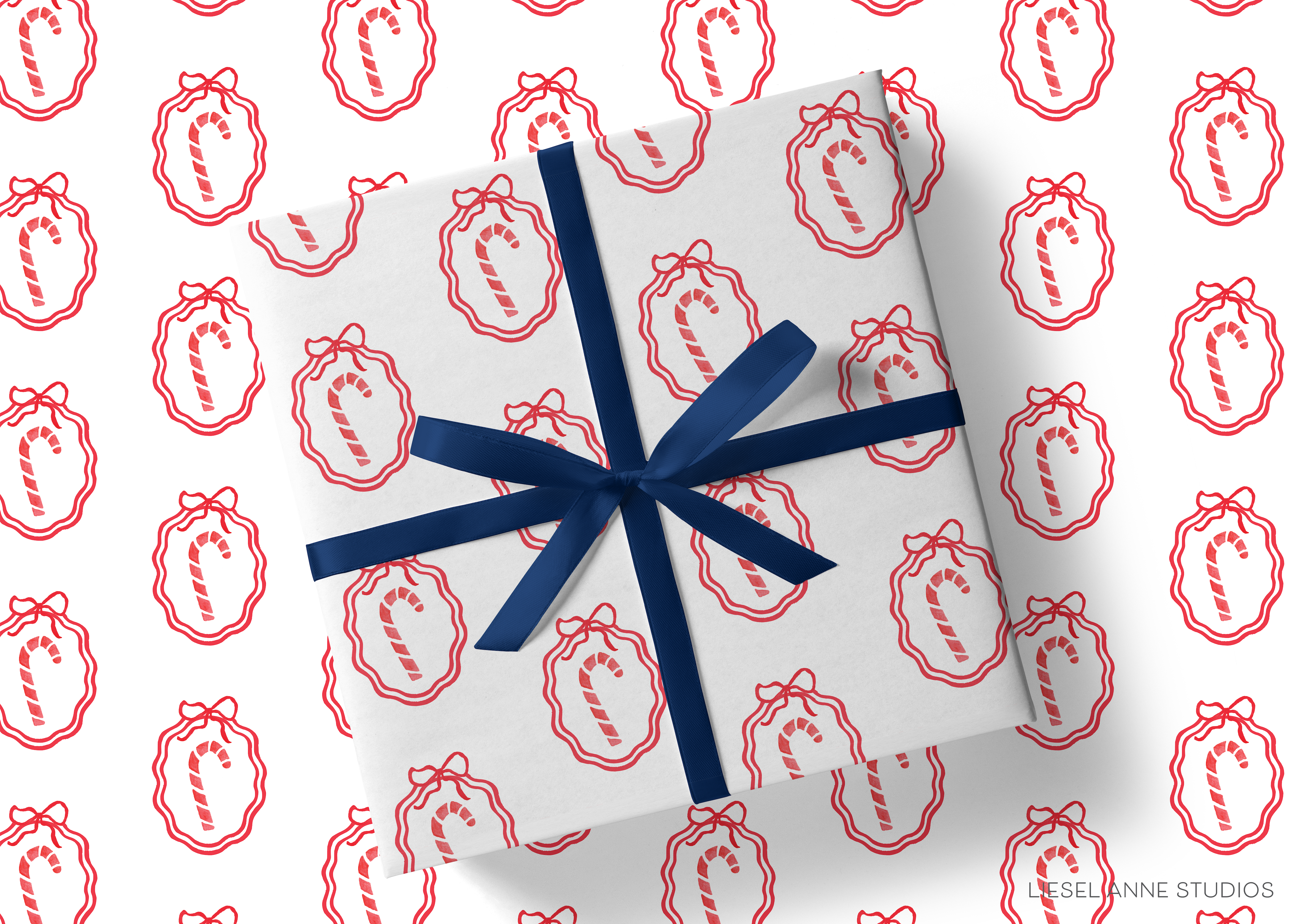 a gift wrapped in a white paper with a blue ribbon, and the paper has a repeating pattern of red candy canes on it.