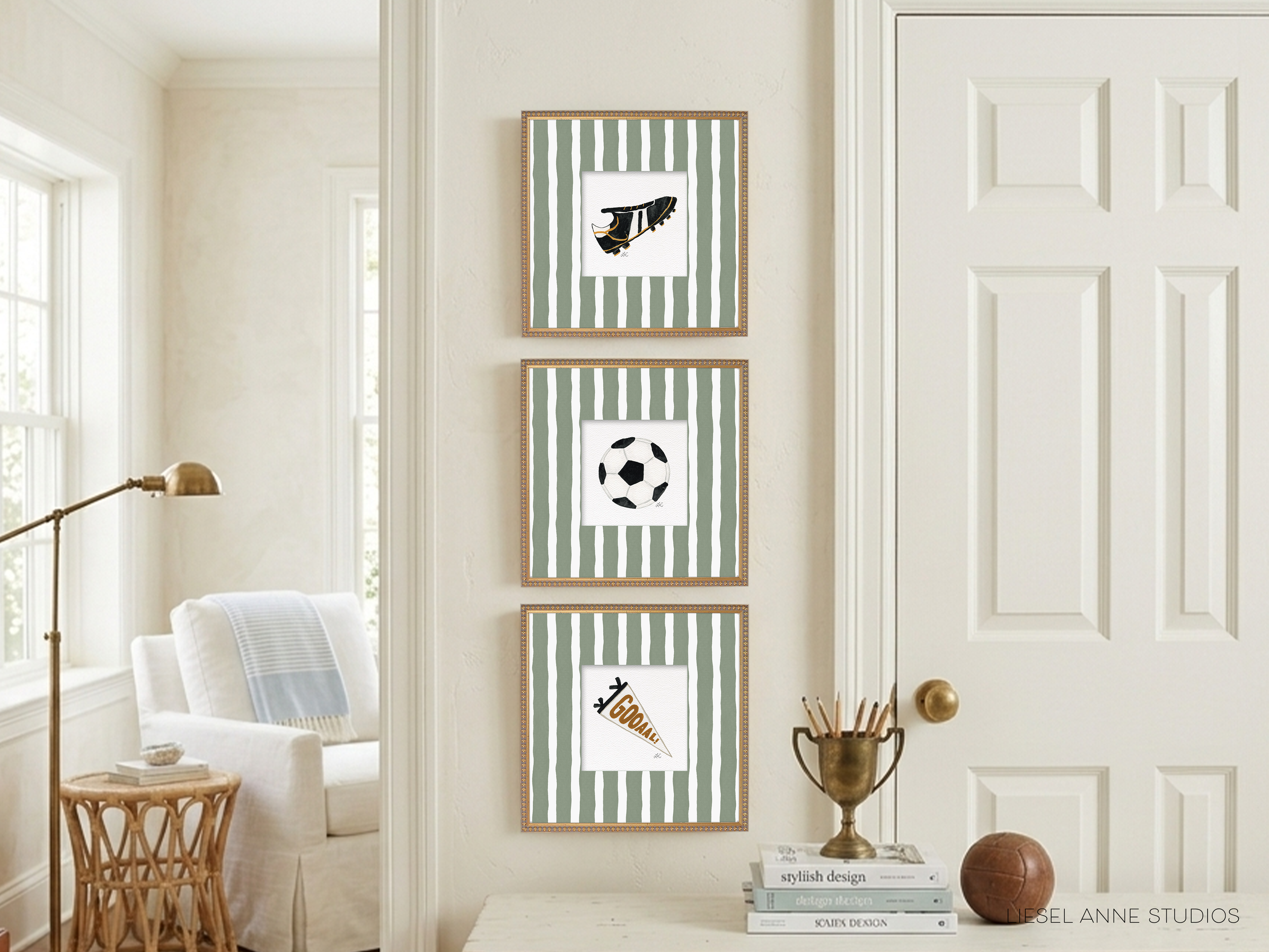 a living room with a white door, a white chair, and a white table. There are three framed pictures on the wall, each with a different sports ball design. The pictures are arranged in a row, creating a visually appealing display.