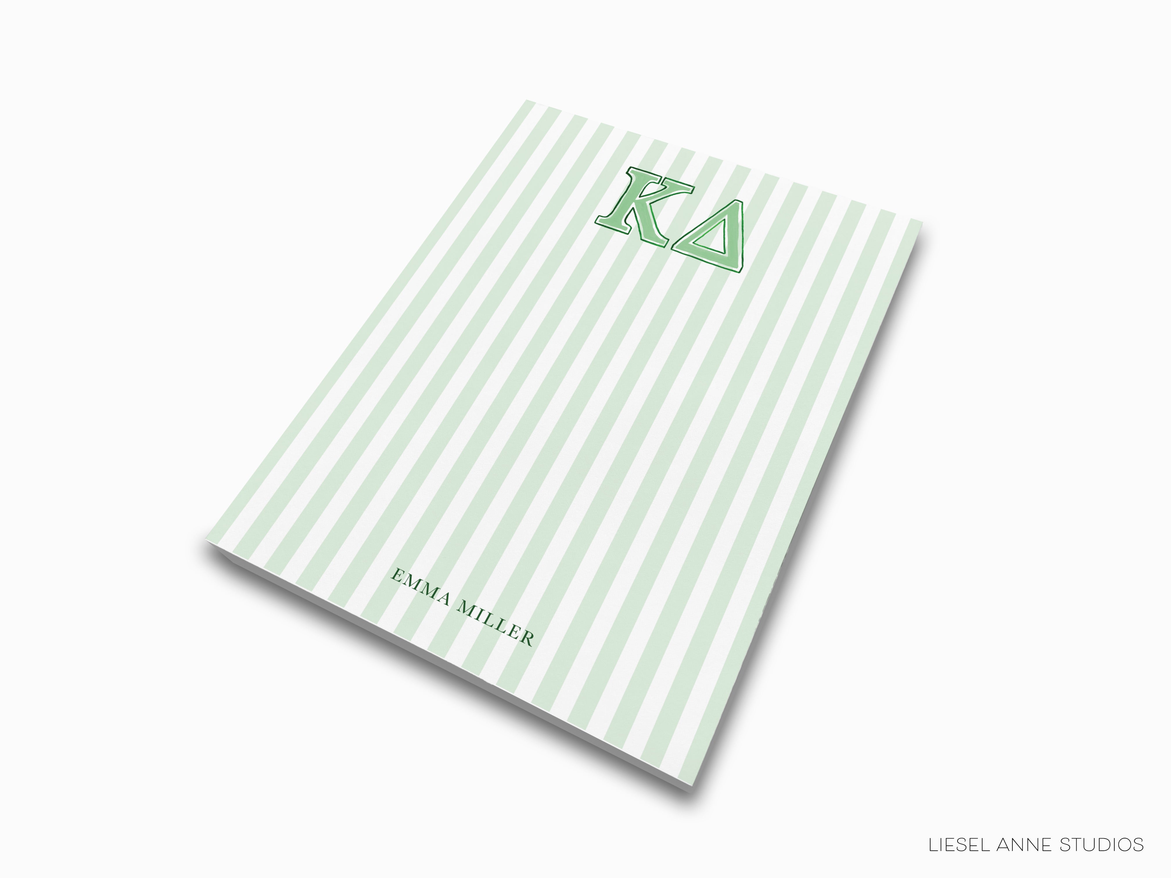 a green and white striped notebook with the letter k on it