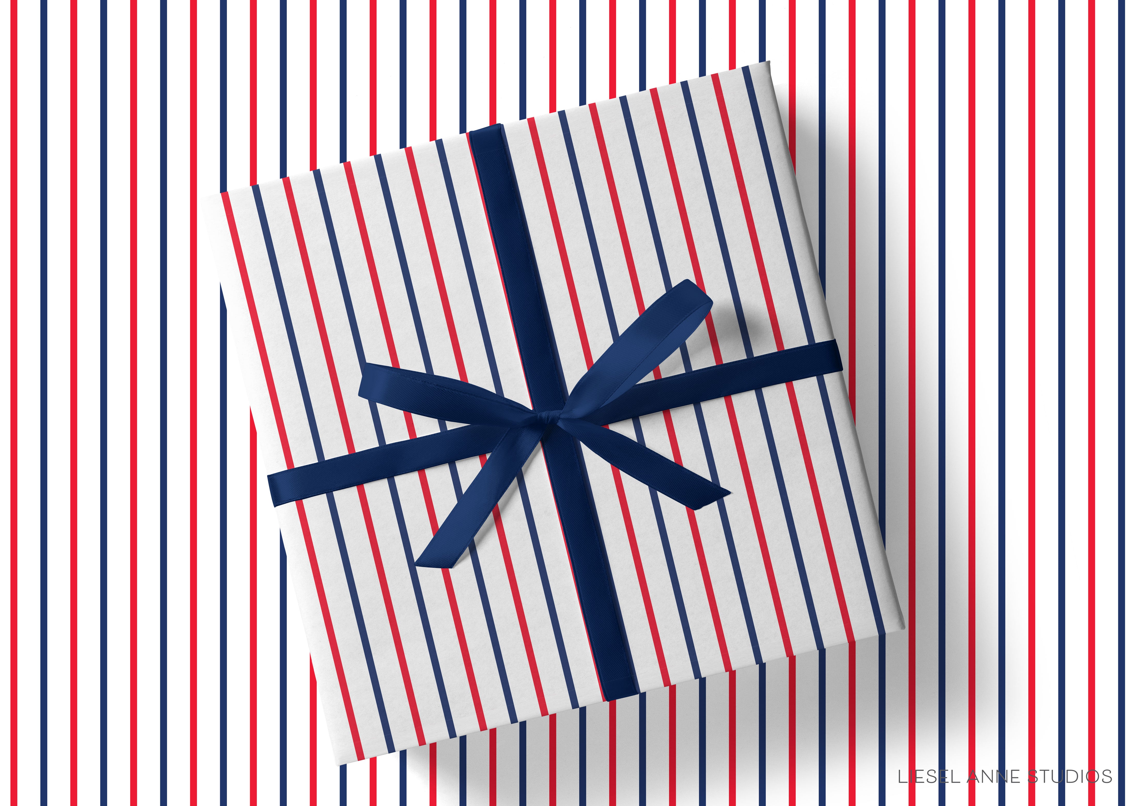 A gift box with a blue ribbon tied around it, placed on a background with red, white, and blue vertical stripes.