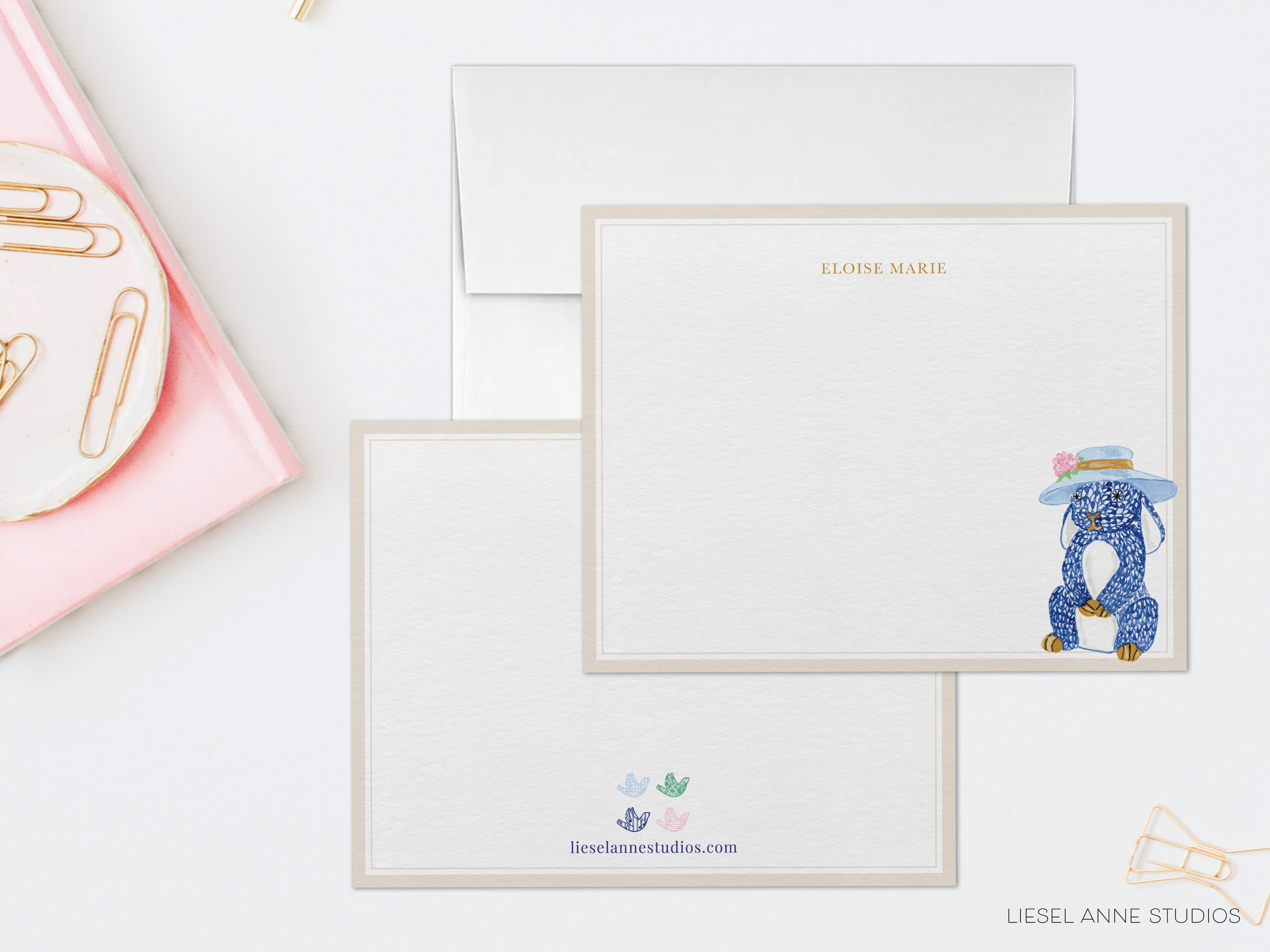 a set of blank cards with a blue elephant illustration on them, placed on a white surface. There is also a pink object and a white object in the background.