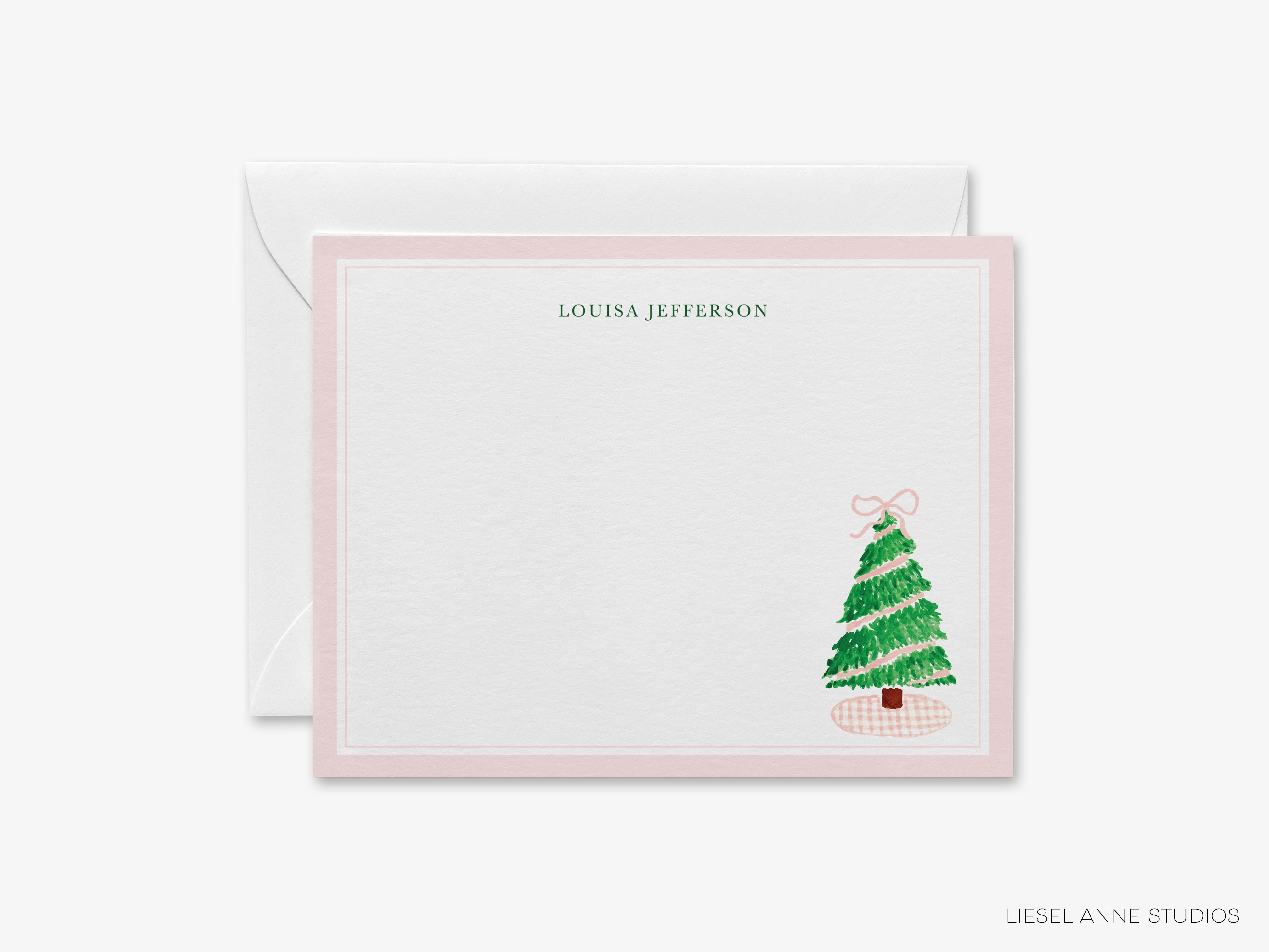 A personalized note card with a Christmas tree illustration and the name "LOUISA JEFFERSON" printed on it.