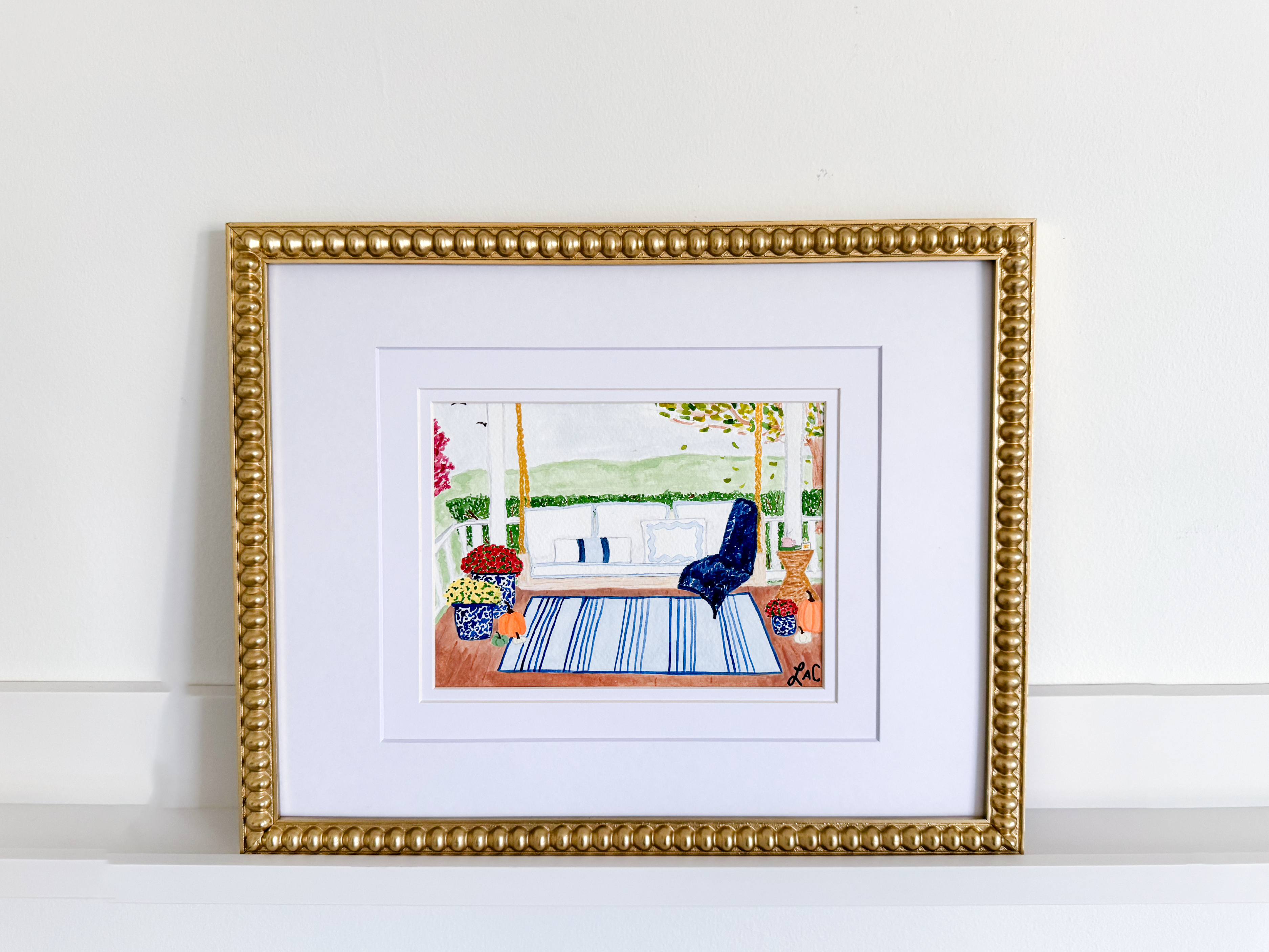 a framed painting of a porch scene with a blue chair, a rug, and potted plants.