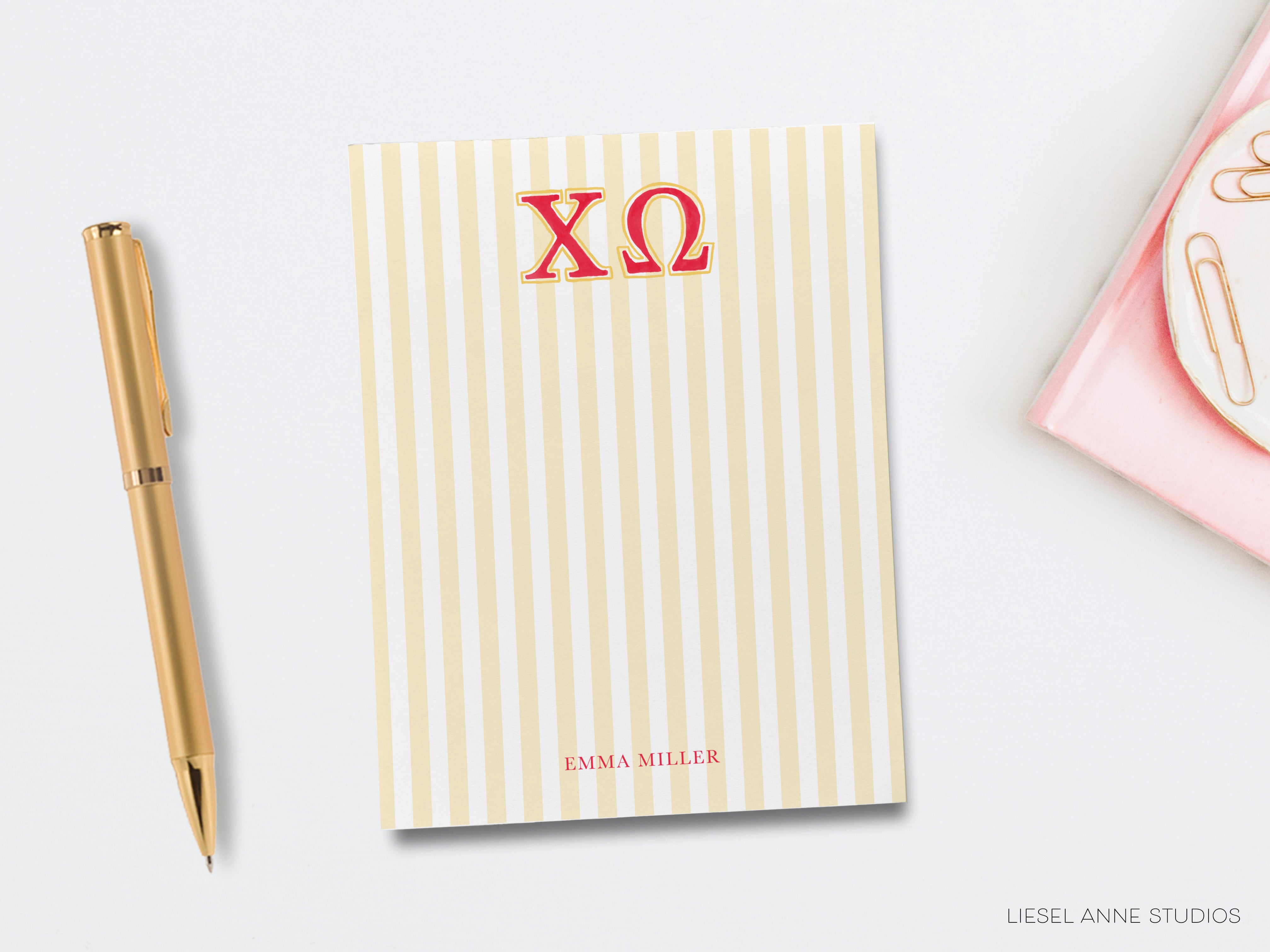 a notepad with the letter xo on it next to a pen