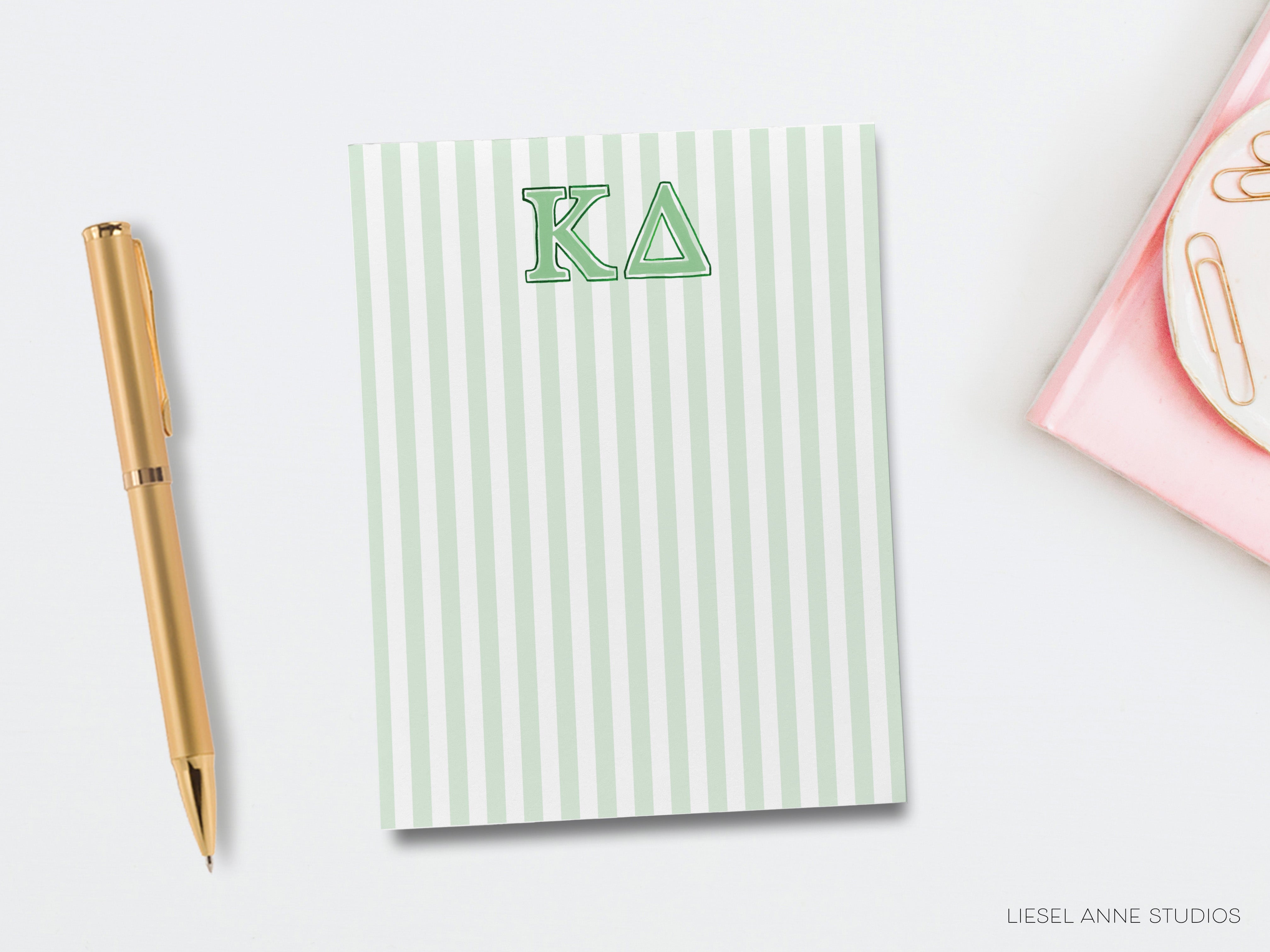 a notepad with the letter k on it next to a pen
