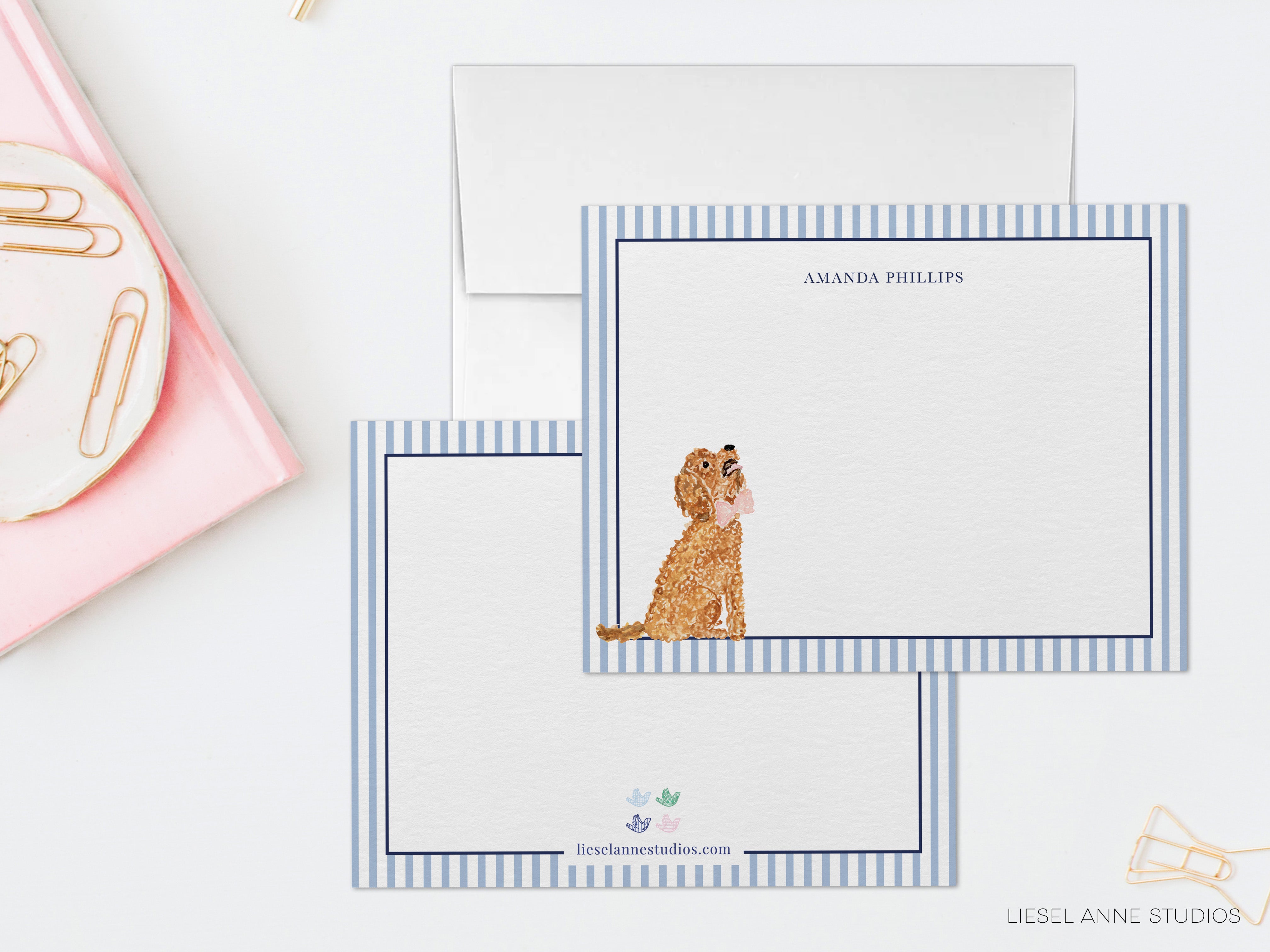 a set of personalized stationery with a dog illustration on the front. The stationery is placed on a white surface, with a pink object and a white envelope visible in the background.