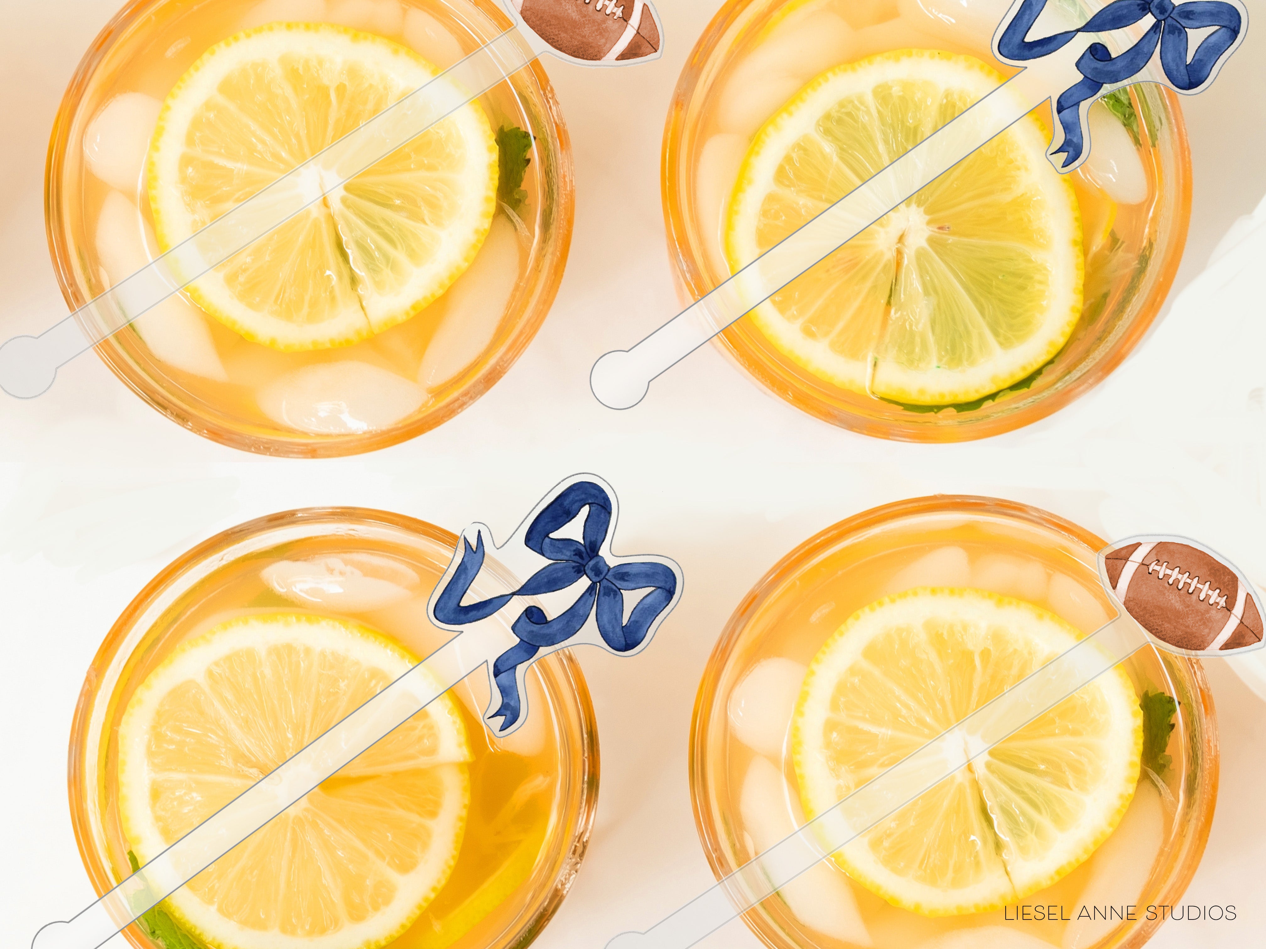 four glasses filled with a yellow liquid, each containing a slice of lemon and a blue ribbon.