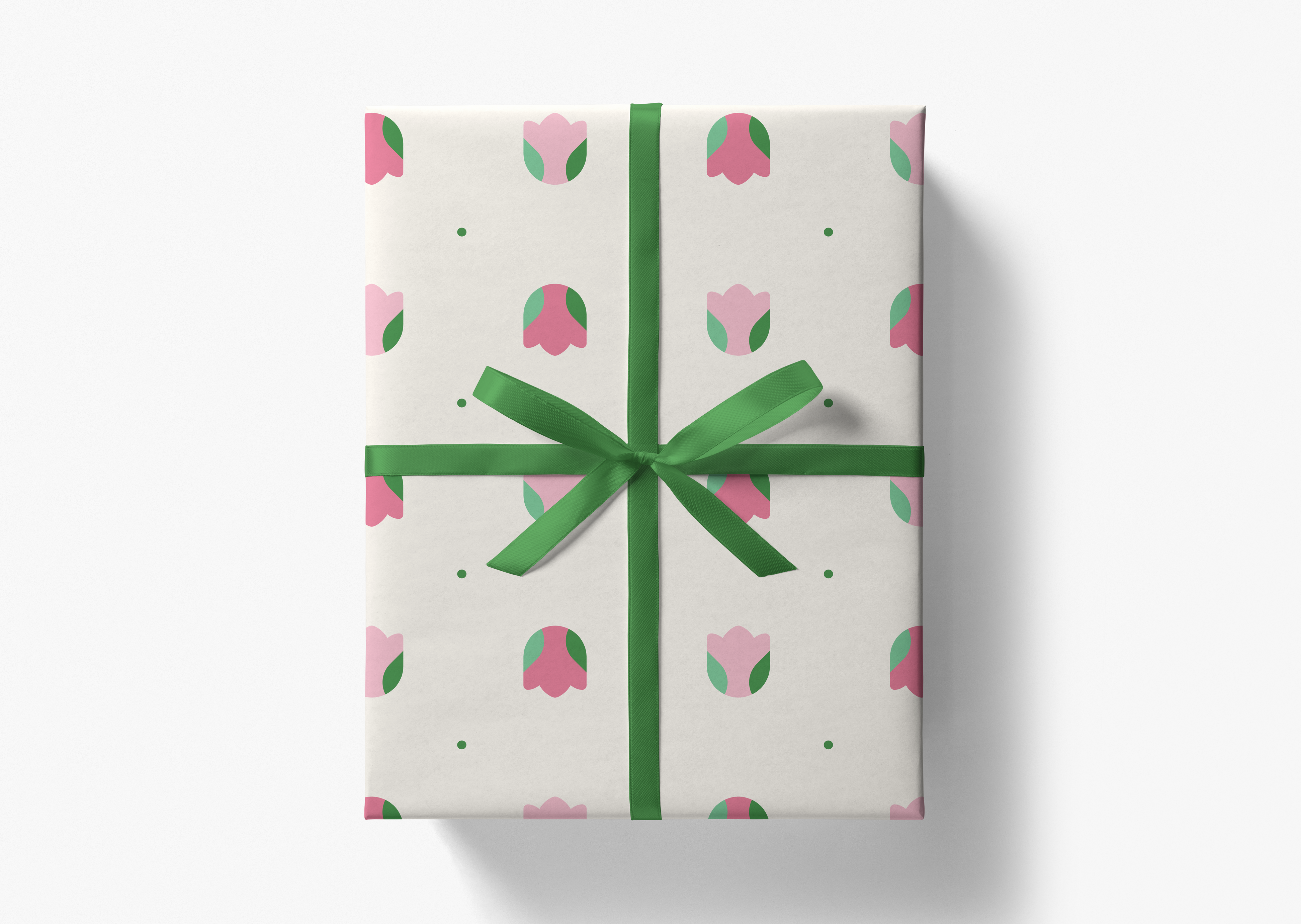 A gift box with a green ribbon and a pattern of pink and green flowers on it.