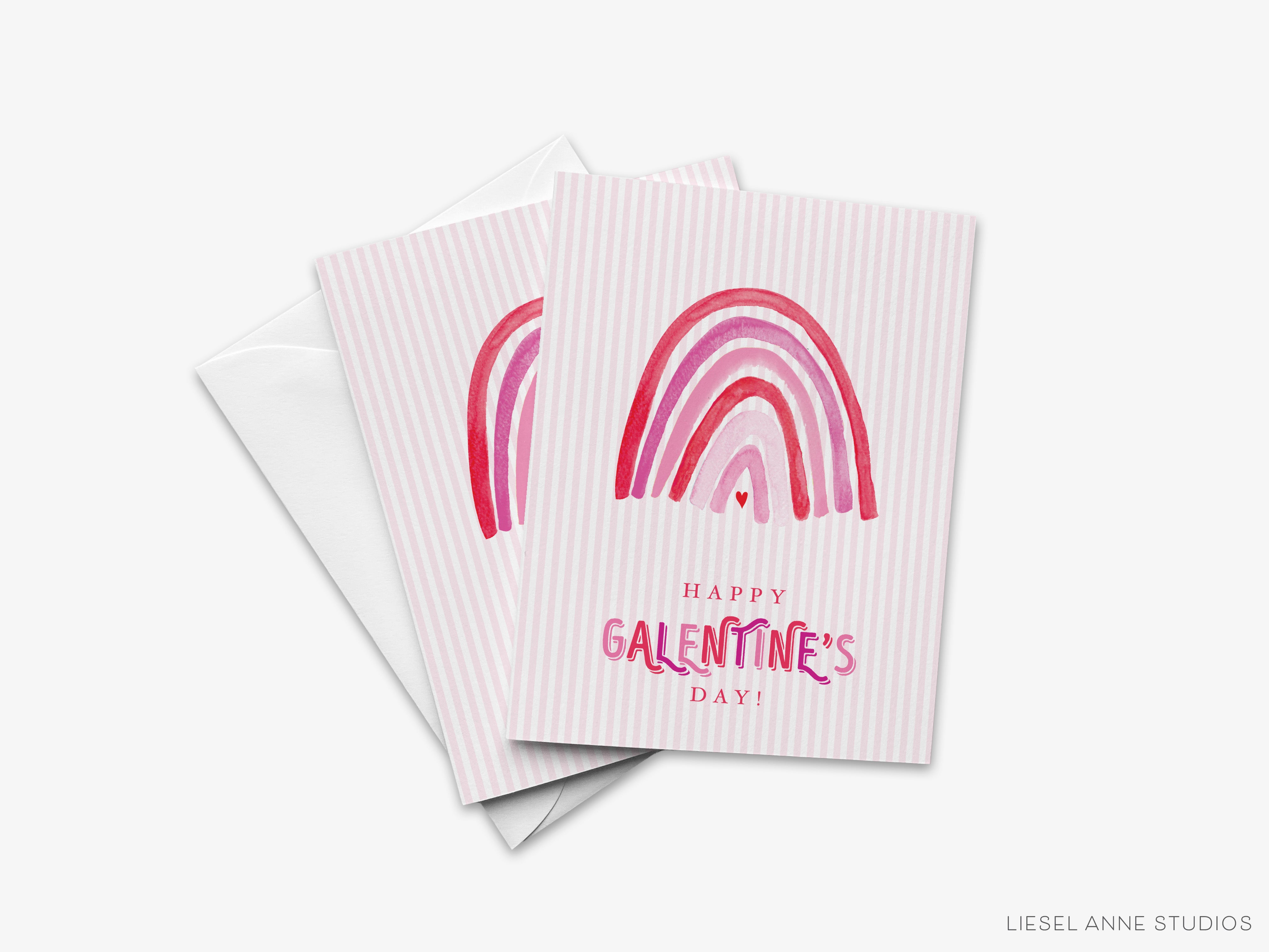 A Valentine's Day card with a pink and white striped background and a rainbow graphic. The card has the text "Happy Galentine's Day!" printed on it.