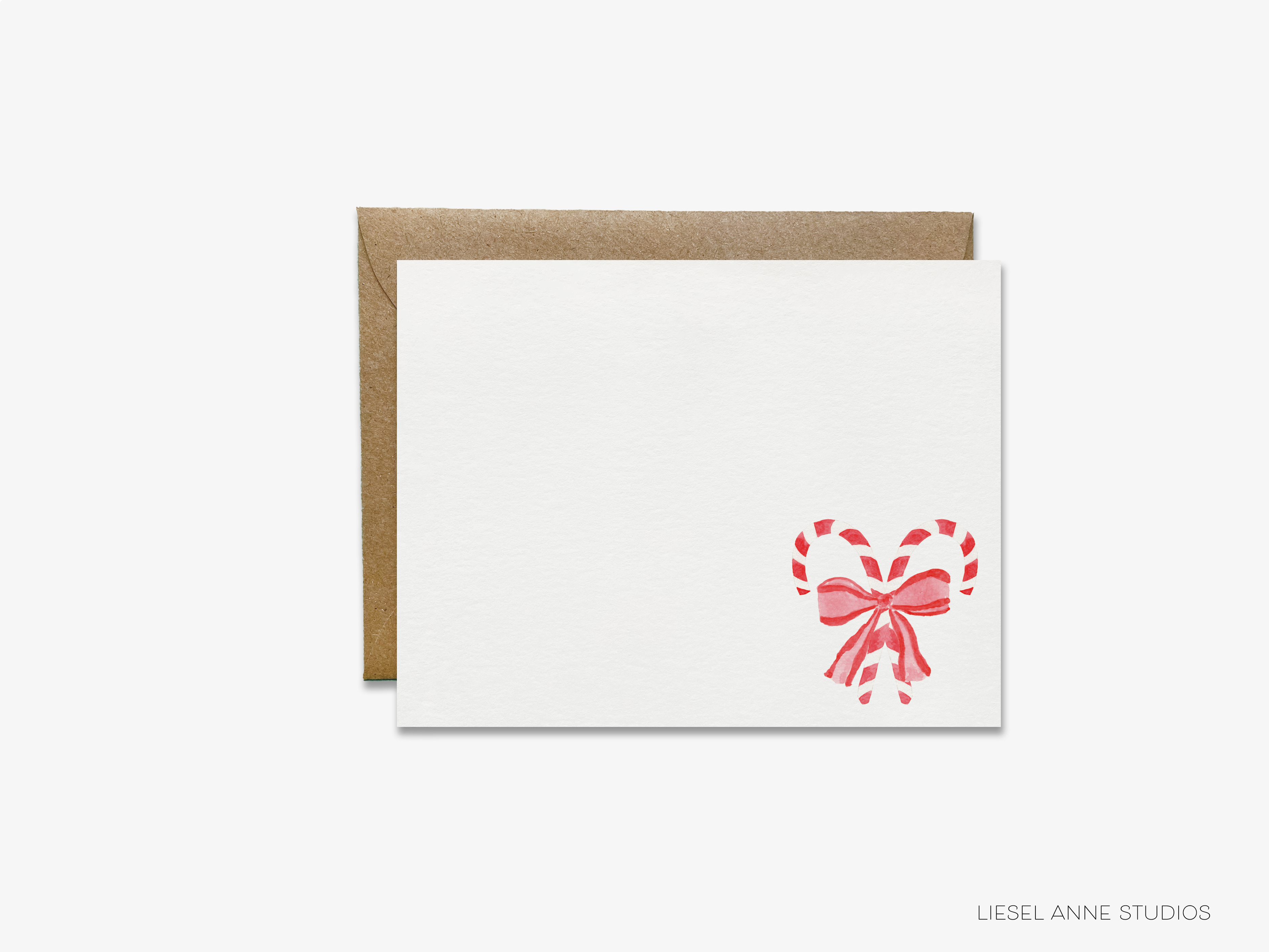 A white card with a red heart-shaped candy decoration and a brown envelope.